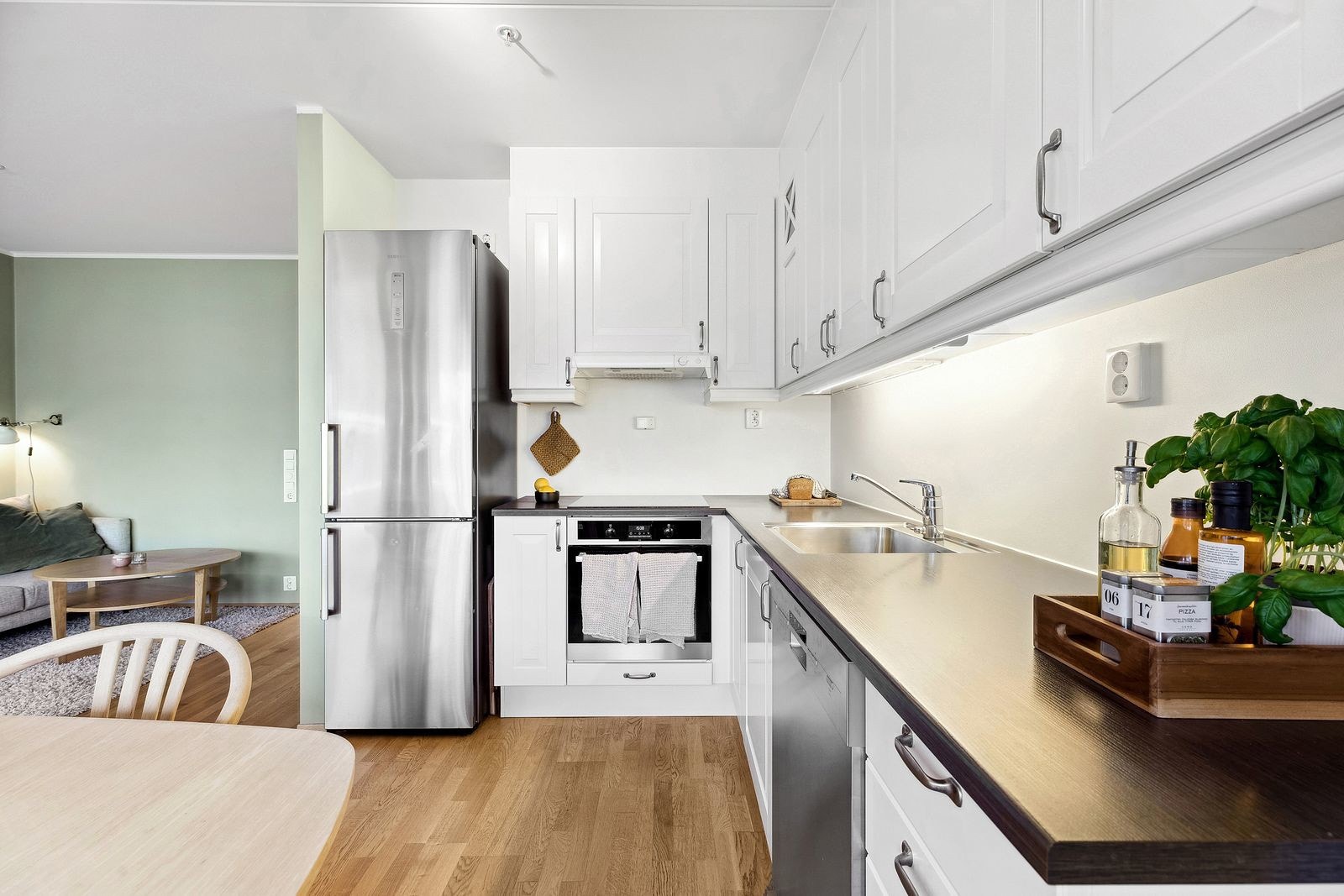 Moderne kjøkken med profilerte fronter og belysning over laminat benkeplate. Galleribilde