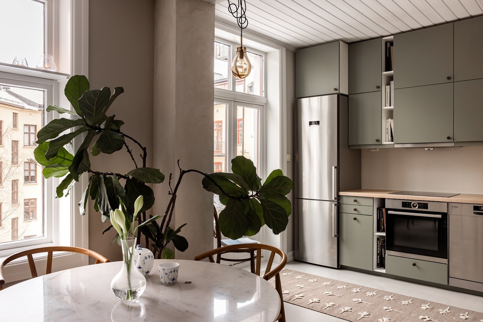 Kjøkkeninnredning med glatte fronter og benkeplate av eikefinèr. Fra kjøkkenet er det utgang til balkong. Galleribilde