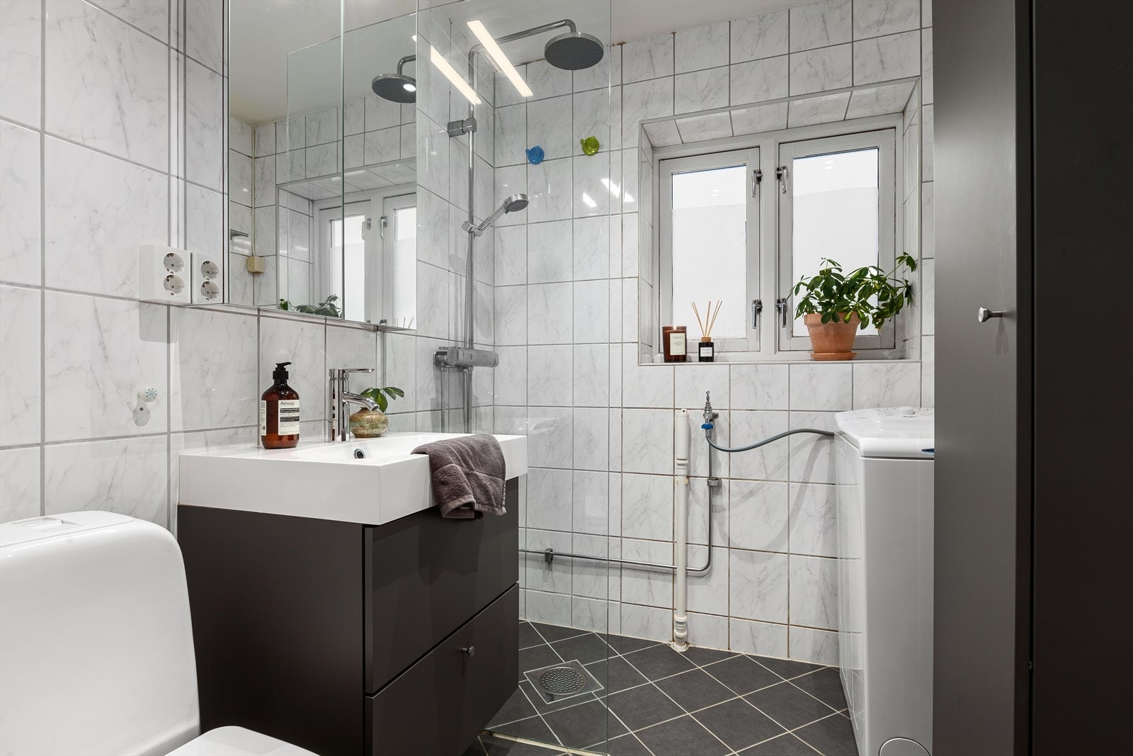 Bad med dusj, wc, servant med underskap, speilskap og opplegg for vaskemaskin. Galleribilde