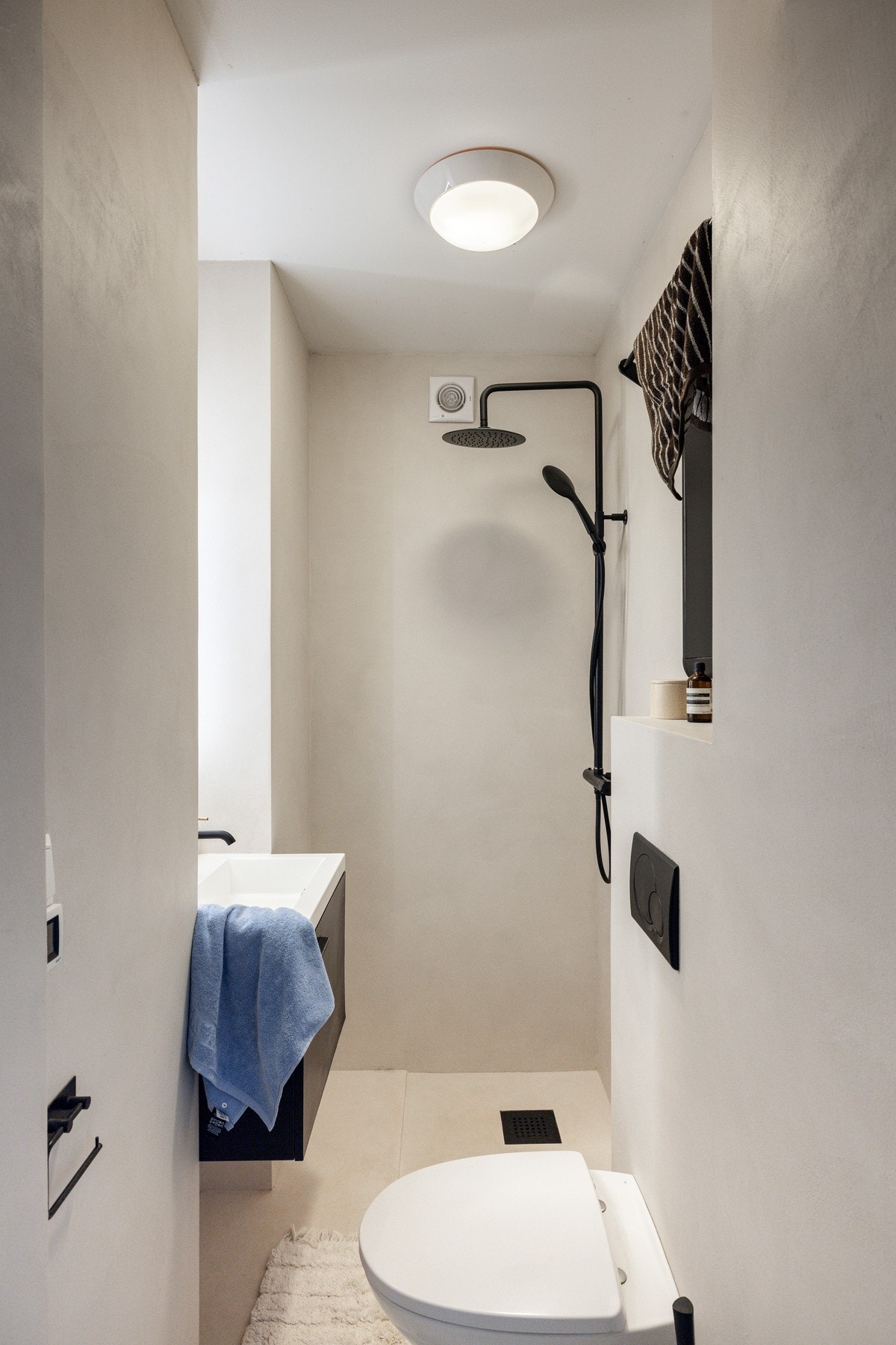 Baderommet består av vegghengt toalett med innebygget sisterne, dusjhjørne og praktisk skap under servant. Galleribilde