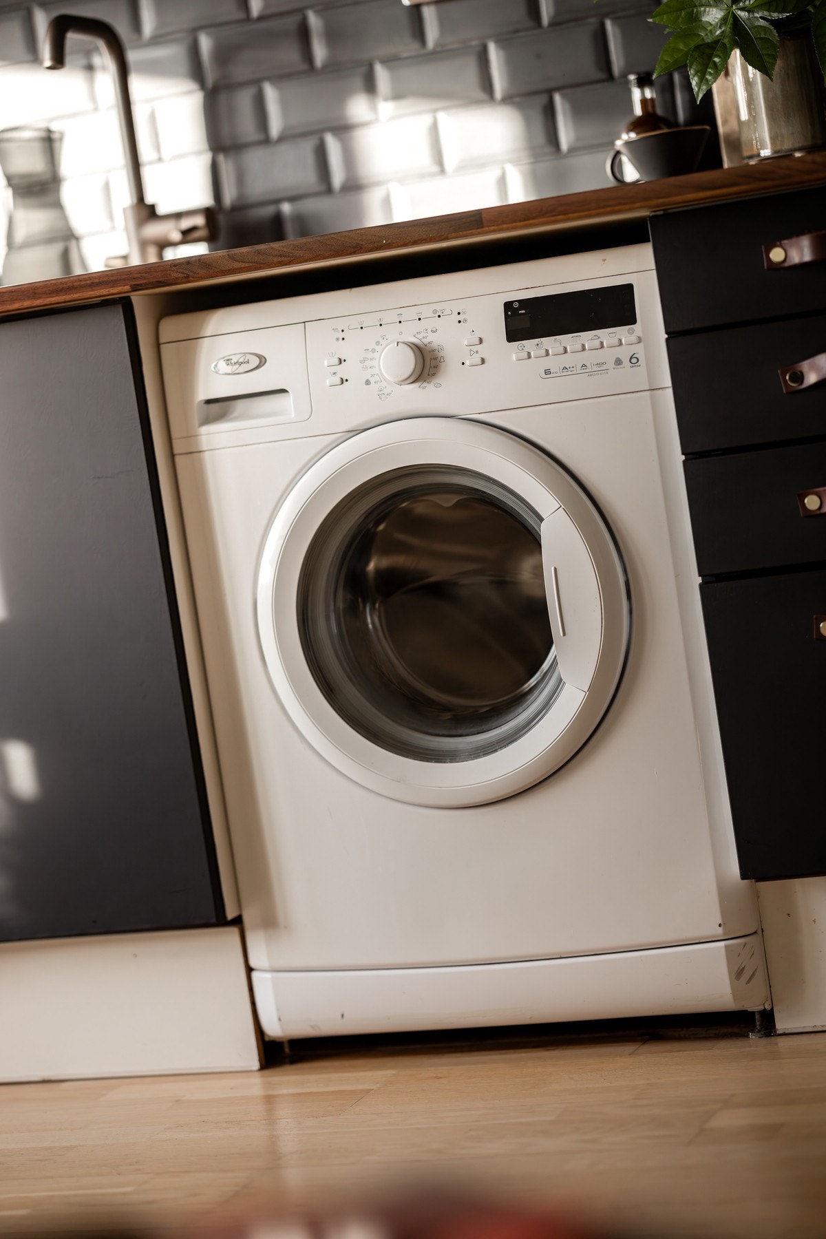 Avsatt plass til vaskemaskin og frittstående kjøleskap med fryser på kjøkkenet. Galleribilde