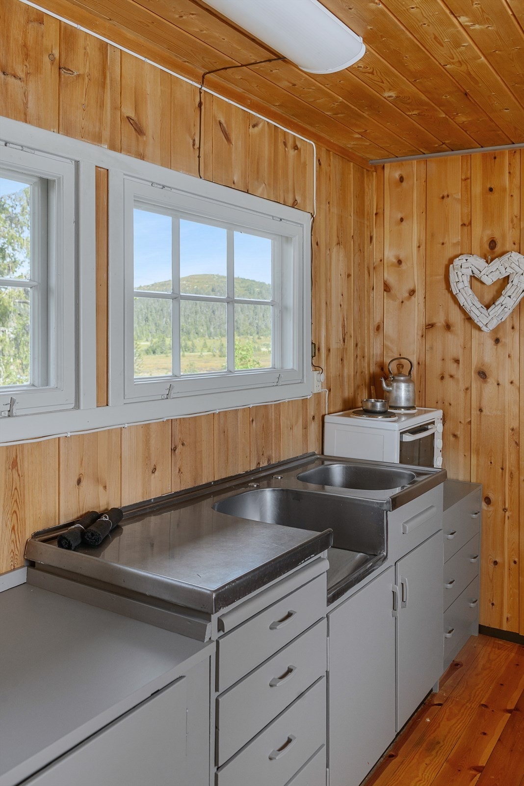 Kjøkkeninnredningen har skap og skuffer. Oppvaskkum. Ikke innlagt vann og avløp til hytta pr i dag. Galleribilde