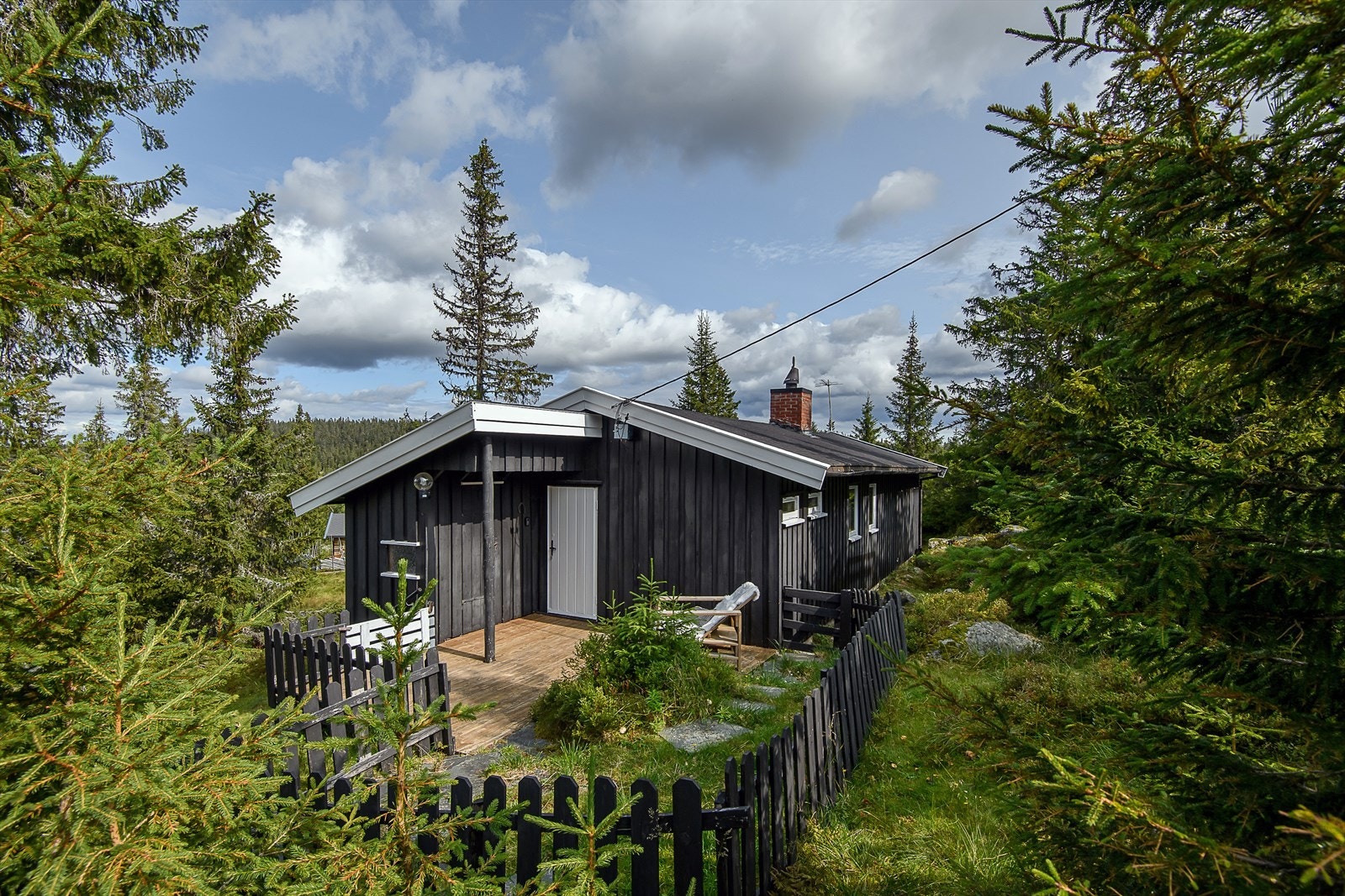 Hytta har en åpen terrasse der en kan slappe av og nyte sola. Galleribilde