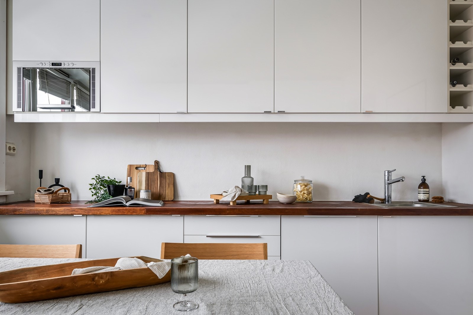 Pen kjøkkeninnredning med god skap- og benkeplass. Innredningen er fra 2009 og har glatte hvite fronter og heltre benkeplate. Galleribilde