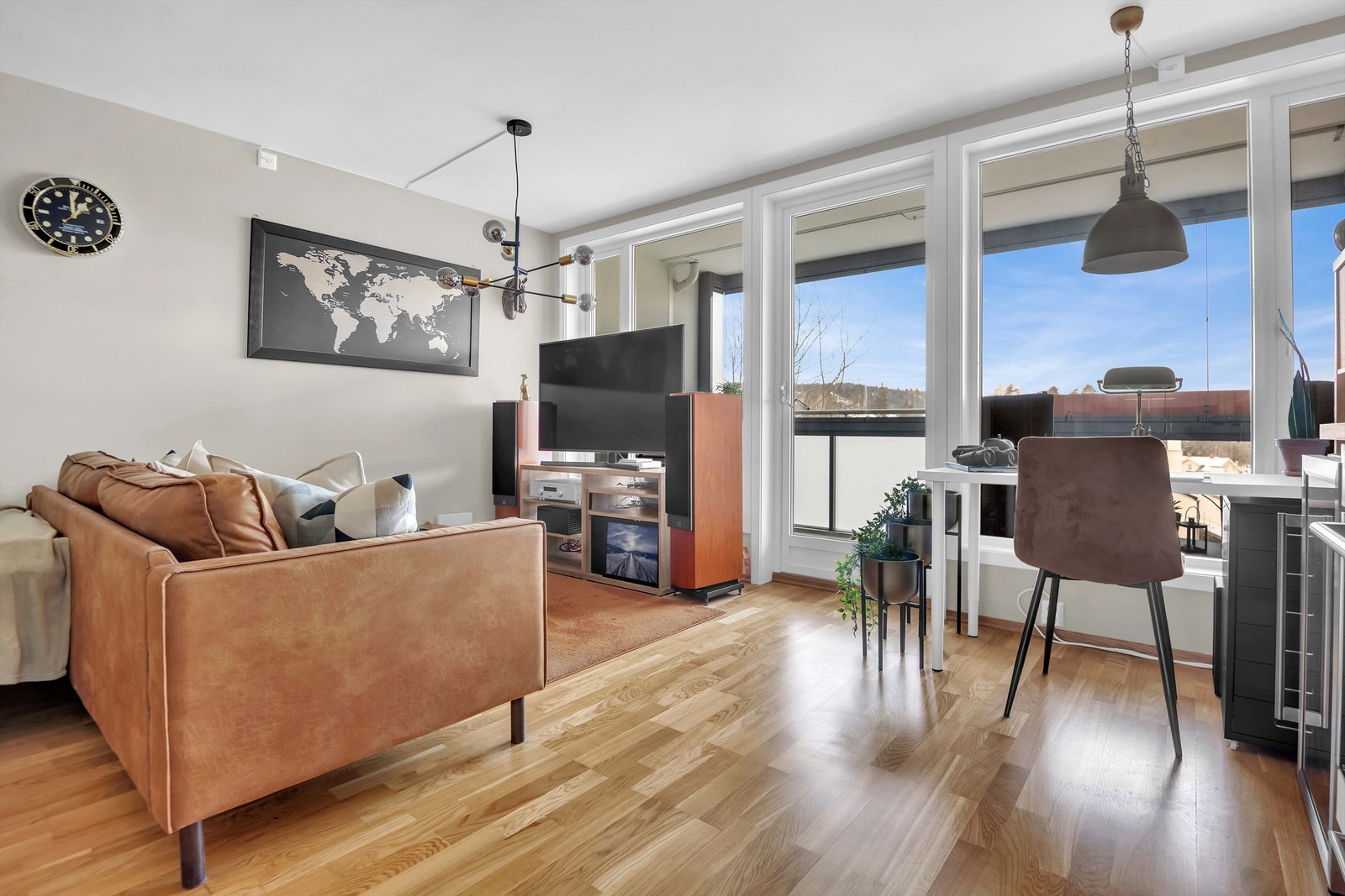 Leiligheten har store vindusflater som gir naturlig lys inn i stuen. Galleribilde