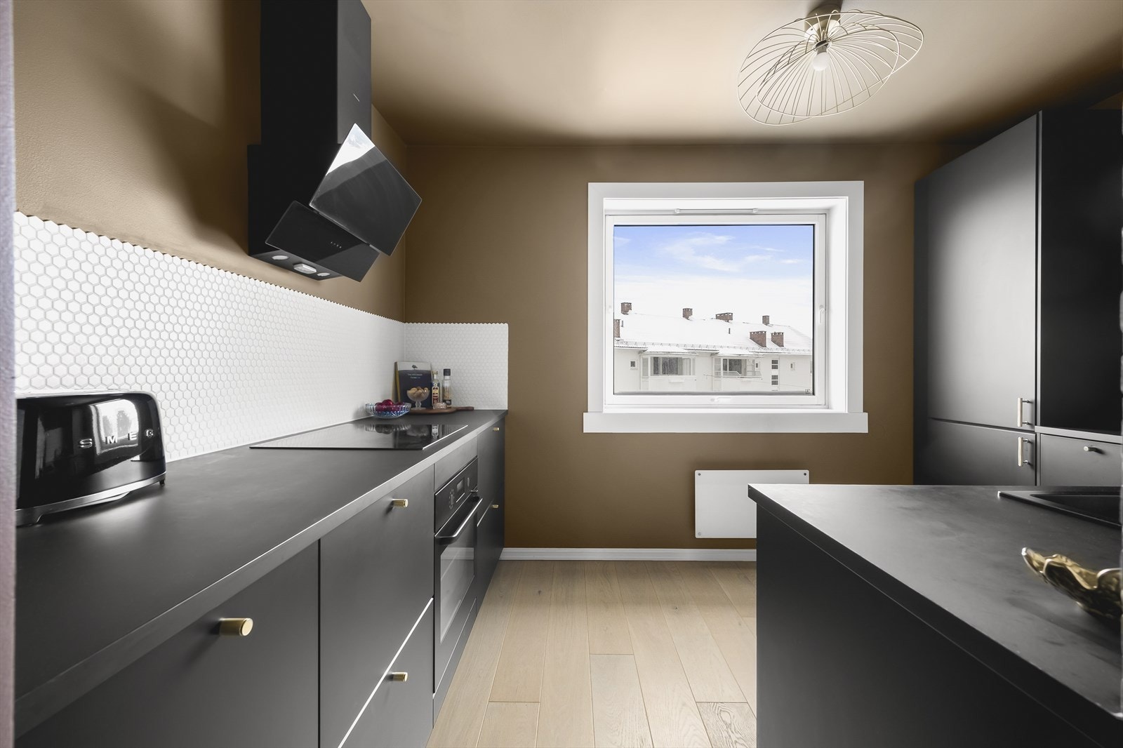 Kjøkkenet ble pusset opp i 2020, og har sorte fronter og benkeplate i laminat. Over benkeplaten er det stilfulle hexagon-fliser. Galleribilde