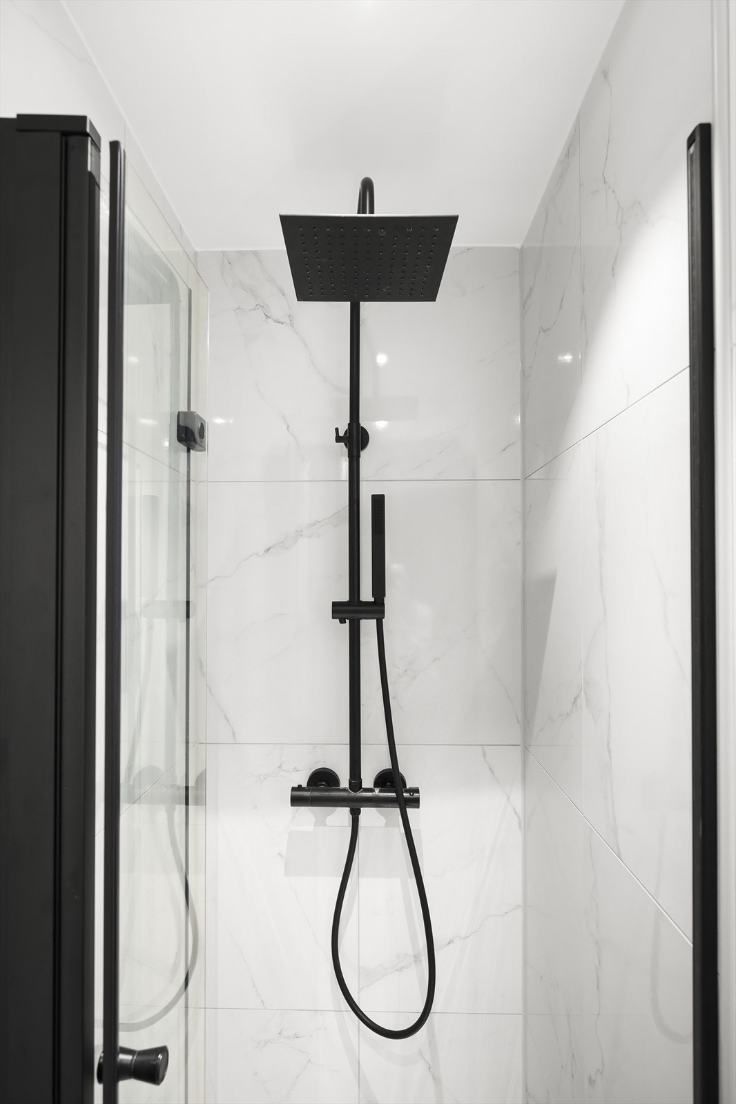 Badet er innredet med vegghengt klosett, dusjhjørne med svingbar glassdør og baderomsinnredning med skap, nedfelt servant og speilskap m/lys. Galleribilde