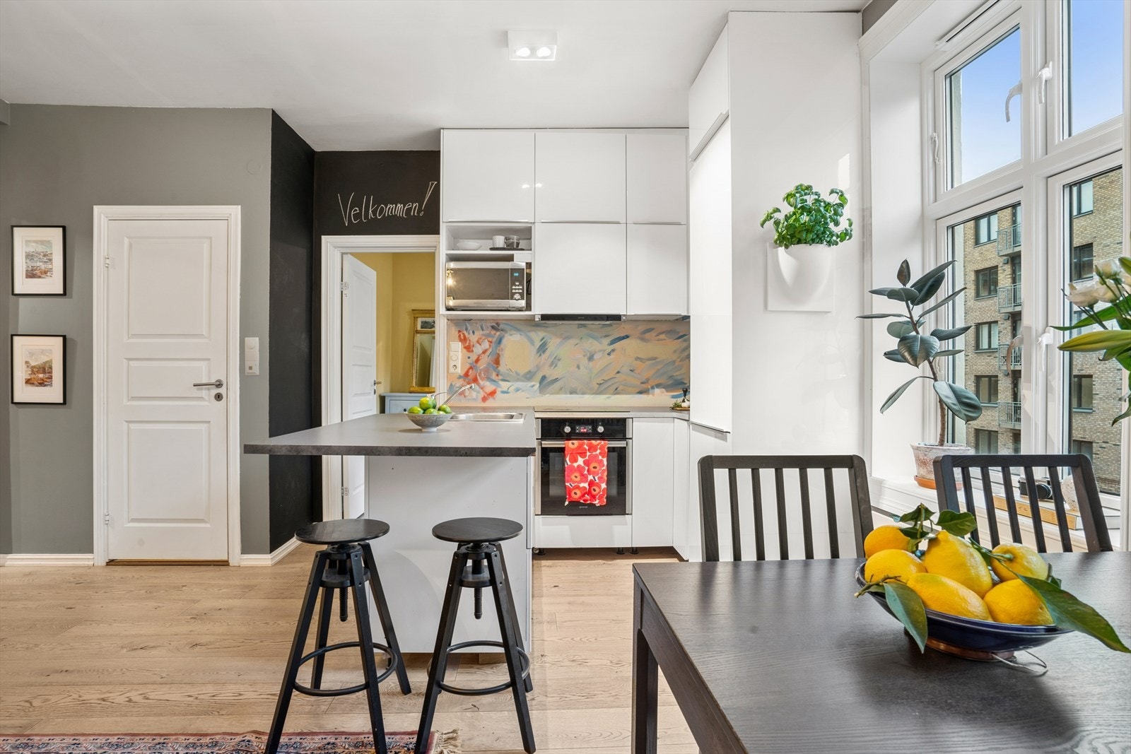 Stilrent kjøkken med tidløse fronter og en funksjonell kjøkkenhalvøy med barstoler Galleribilde