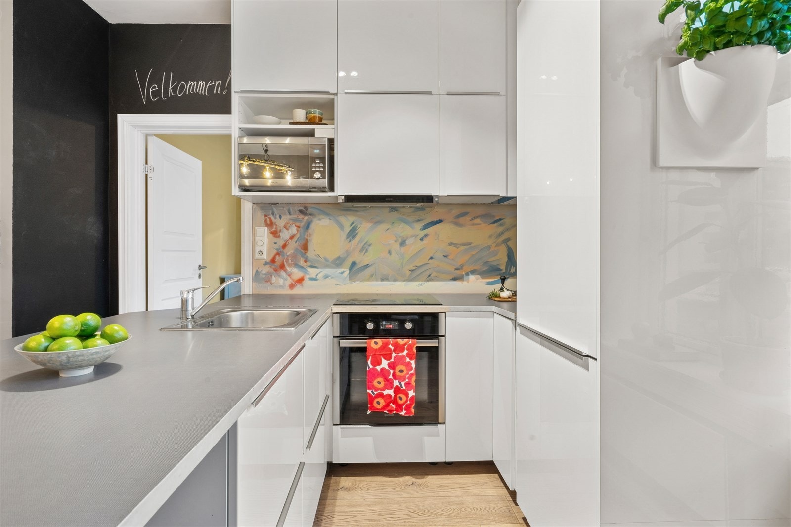 Kjøkkenet består av folierte høyglansfronter, laminat benkeplate, enkel oppvaskkum, kjøkkenventilator i stål, frittstående mikro og oppvaskmaskin samt integrerte hvitevarer Galleribilde