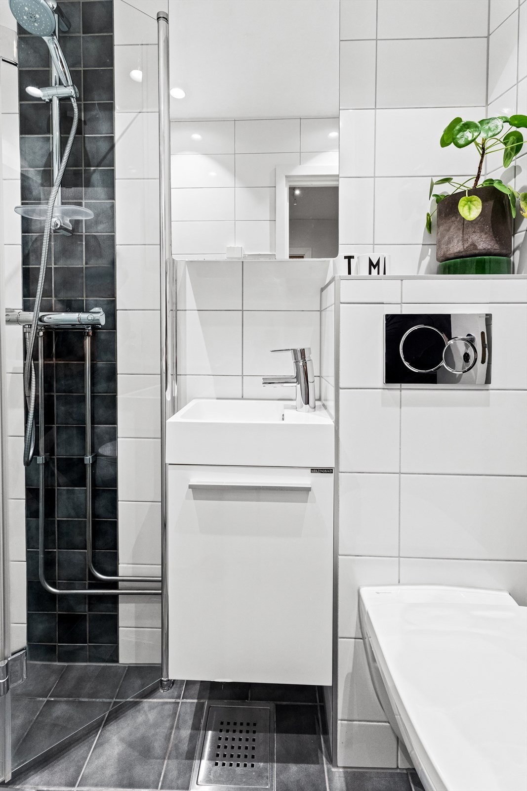 Benkeskap med glatte fronter, overskap med speilfront og downlights på bad installert 2021. Galleribilde