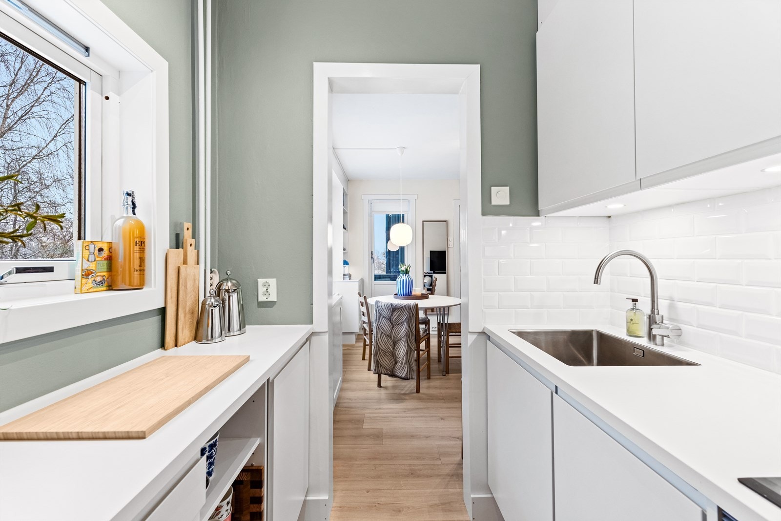 Meget pene fliser på vegg over benkeplate og belysning under overskap. Galleribilde