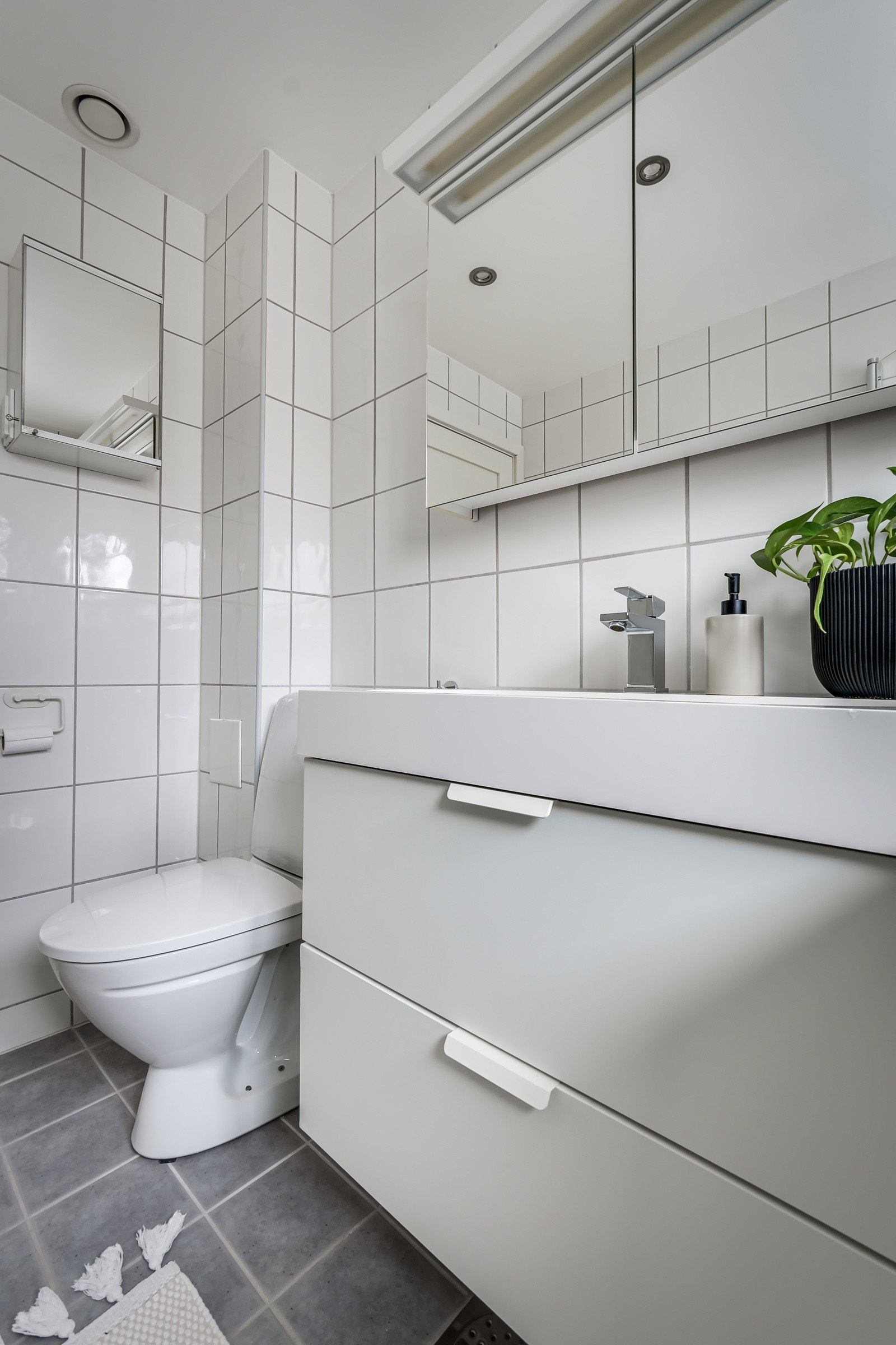 Moderne innredning med servantskap med skuffer og heldekkende servant med ett-greps armatur, speilskap med belysning, dusjhjørne med innfellbare glassdører og dusjarmatur tilkoblet hånddusj, samt gulvstående toalett. Gulvvarme. Downlights. Galleribilde