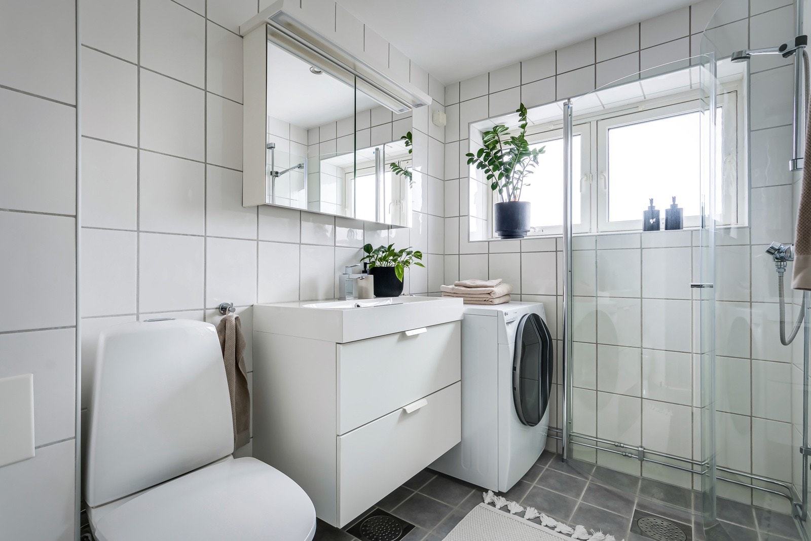 Tidløst flislagt baderom, oppusset i regi av borettslaget i 2008/09. Baderommet har lyse fliser på både gulv og vegger. Galleribilde