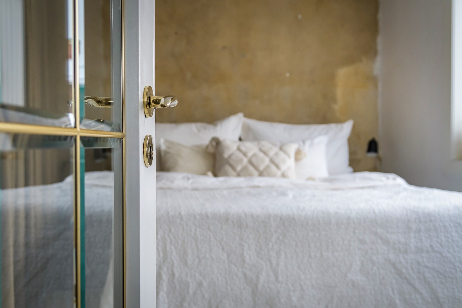 God standard med originalt tregulv og glatte lysmalte overflater som passer veldig godt sammen med den tøffe betongveggen bak sengen. Galleribilde