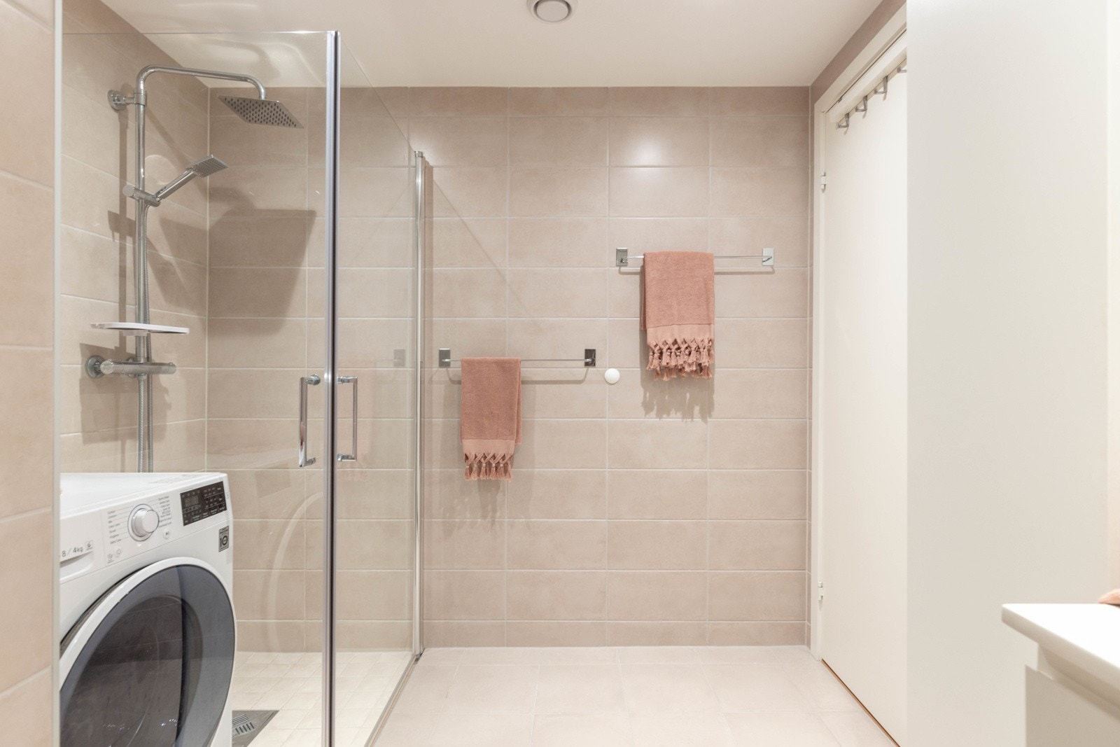 Dusjhjørne med foldedører og dusjgarnityr med regndusj. Det er vannbåren varme i gulvet. Galleribilde