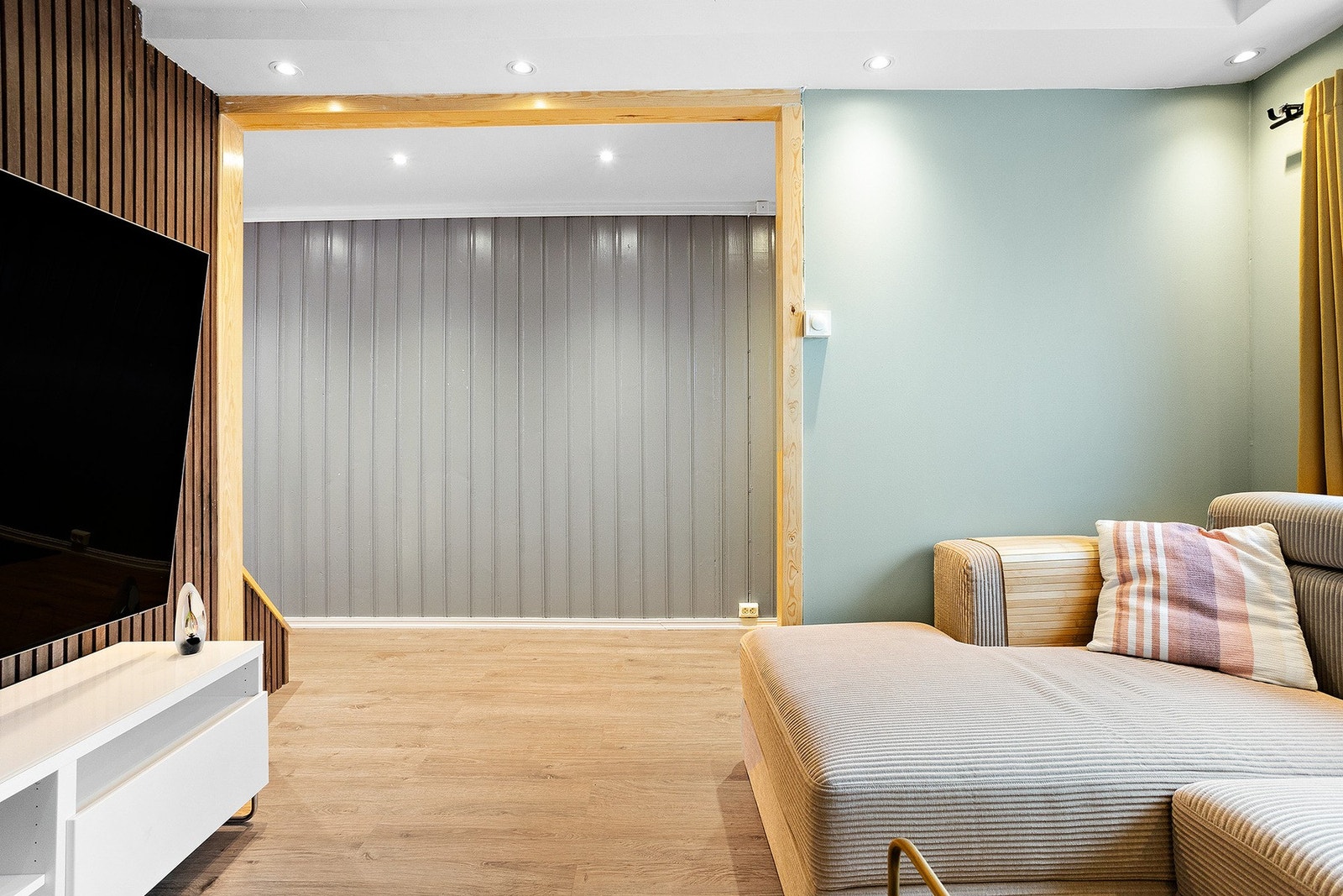 Med en moderne spilevegg som kontrast, spotter i taket og vegger i en harmonisk grønn-blå nyanse, er det en perfekt plass for avslapping. Galleribilde