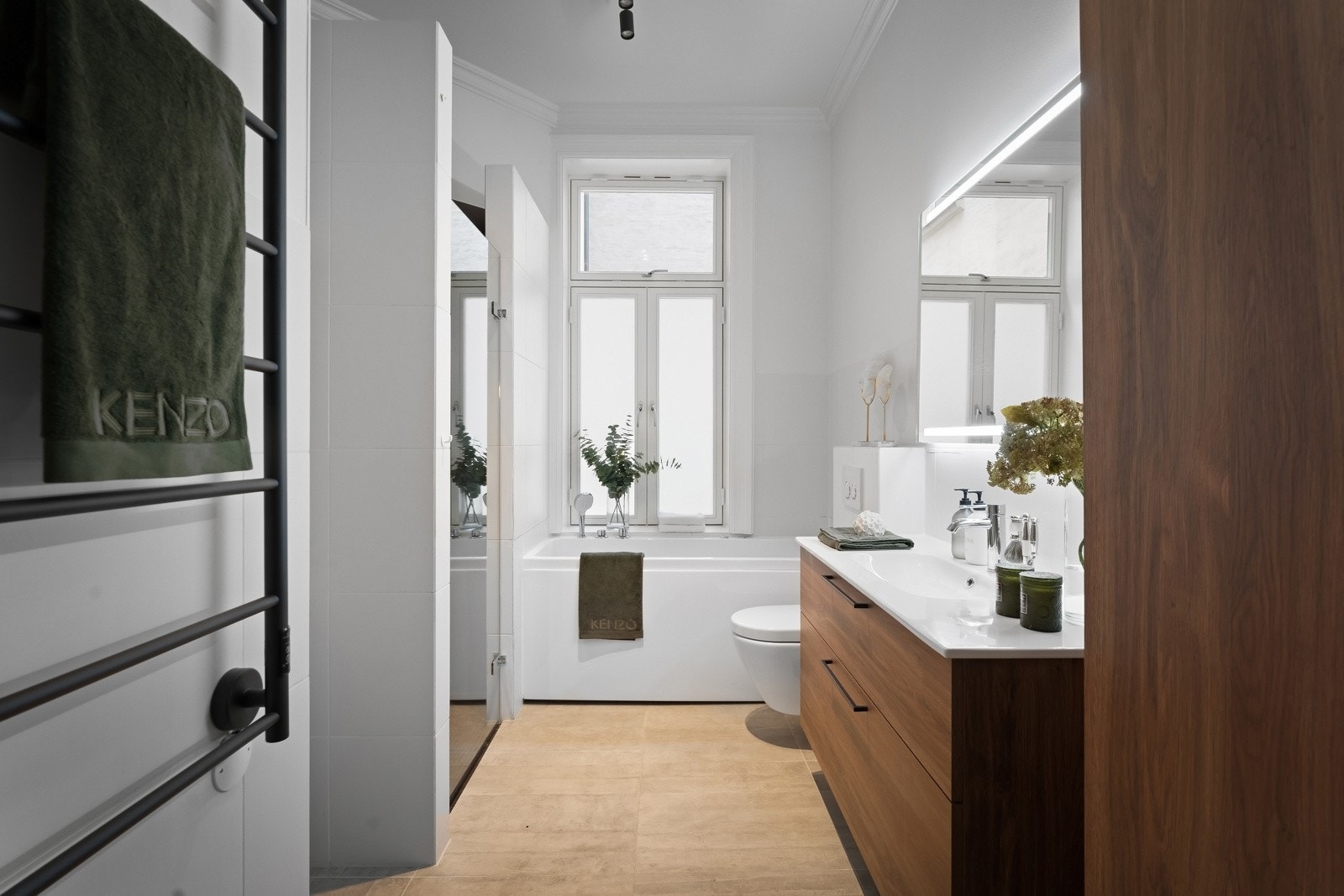 Et moderne og funksjonelt bad med flislagte overflater og varme i gulvet for ekstra komfort Galleribilde