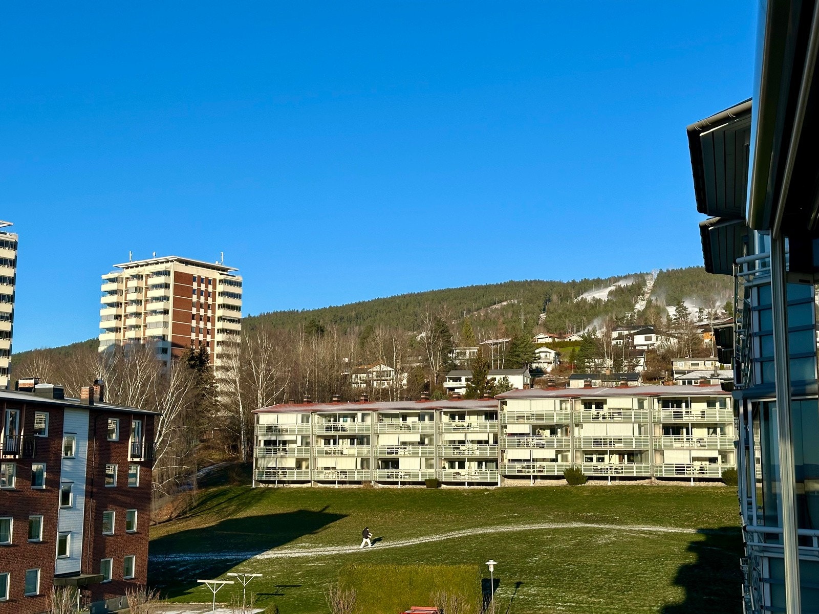 Utsikt fra innglasset balkong - produksjon av snø i full gang i Drammen skisenter. Galleribilde