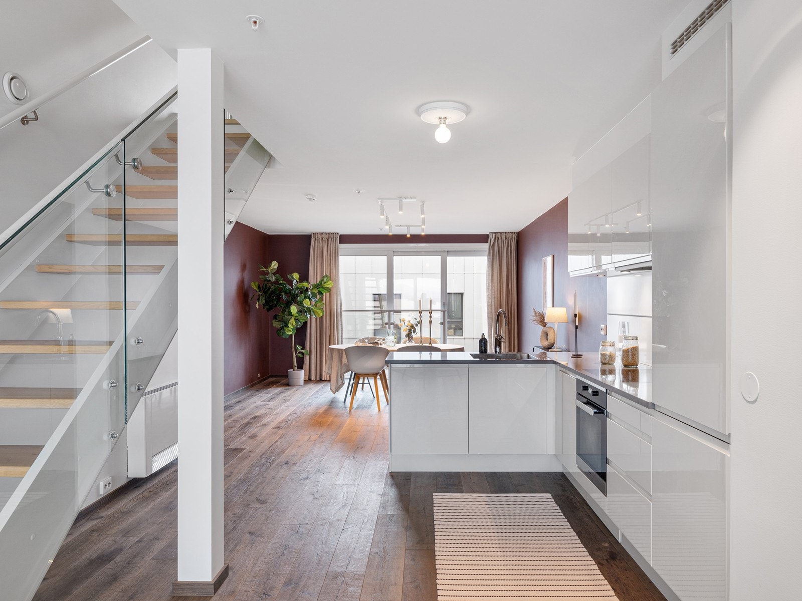 Lekkert kjøkken som står sentrert i rommet og som med granitt benkeplate, planlimt vask og spotter under skap fremstår som det perfekte midtpunkt. Galleribilde