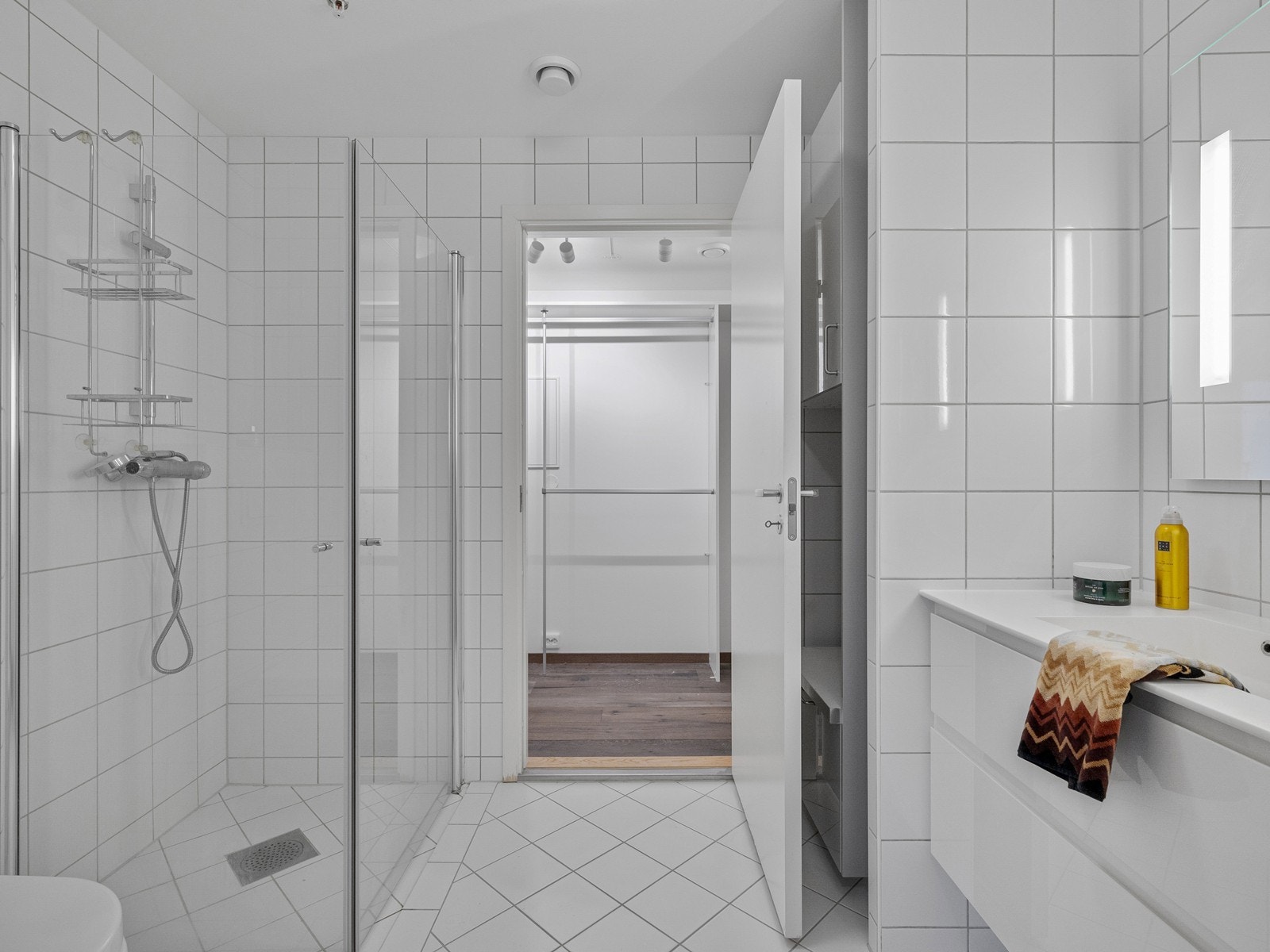 Baderommet ved inngangspartiet er helfliset med vannbåren gulvvarme. Bod/garderoberom innenfor badet. Galleribilde