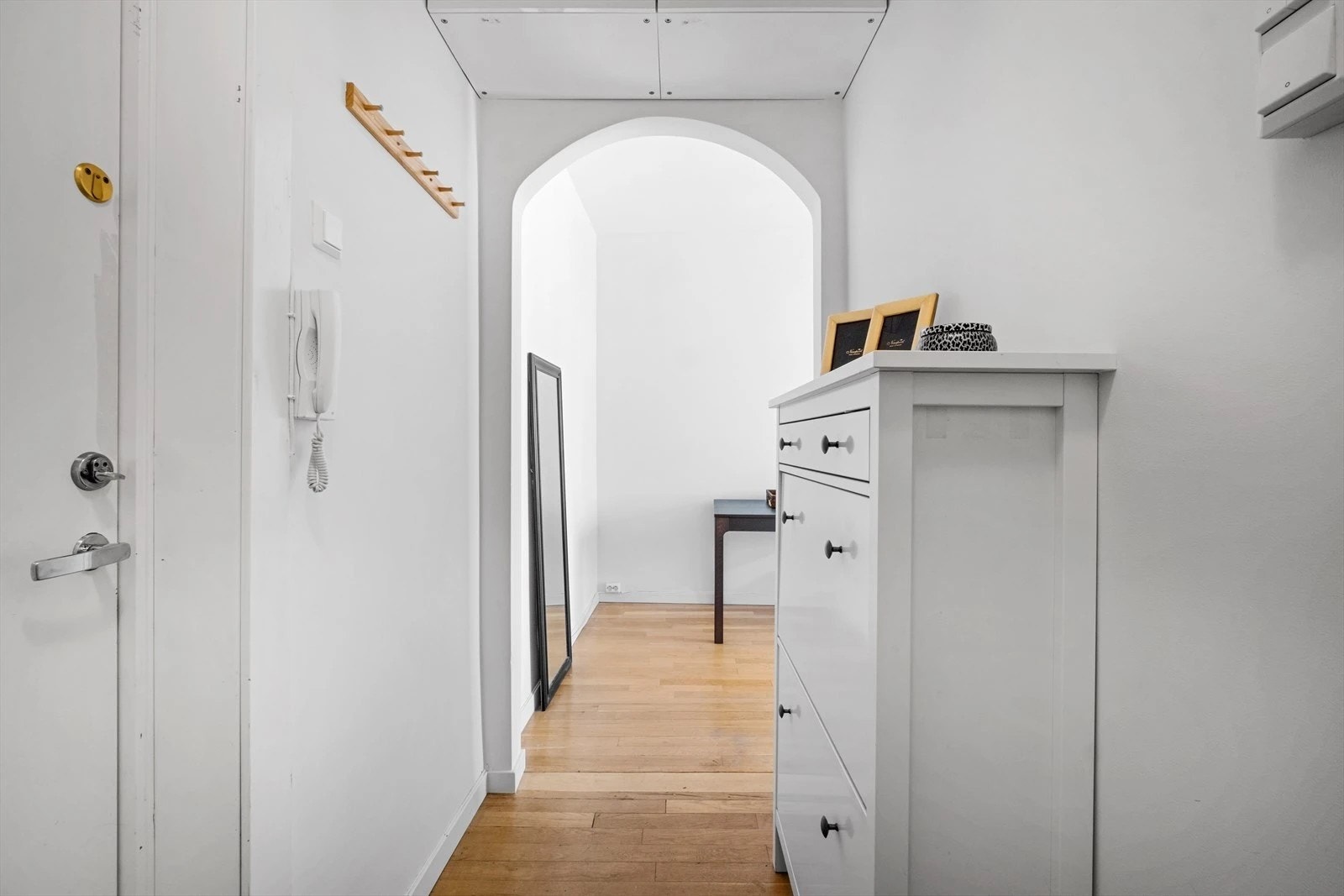 Den buede formen på inngangen til stuet er beholdt med smart lagring over Galleribilde