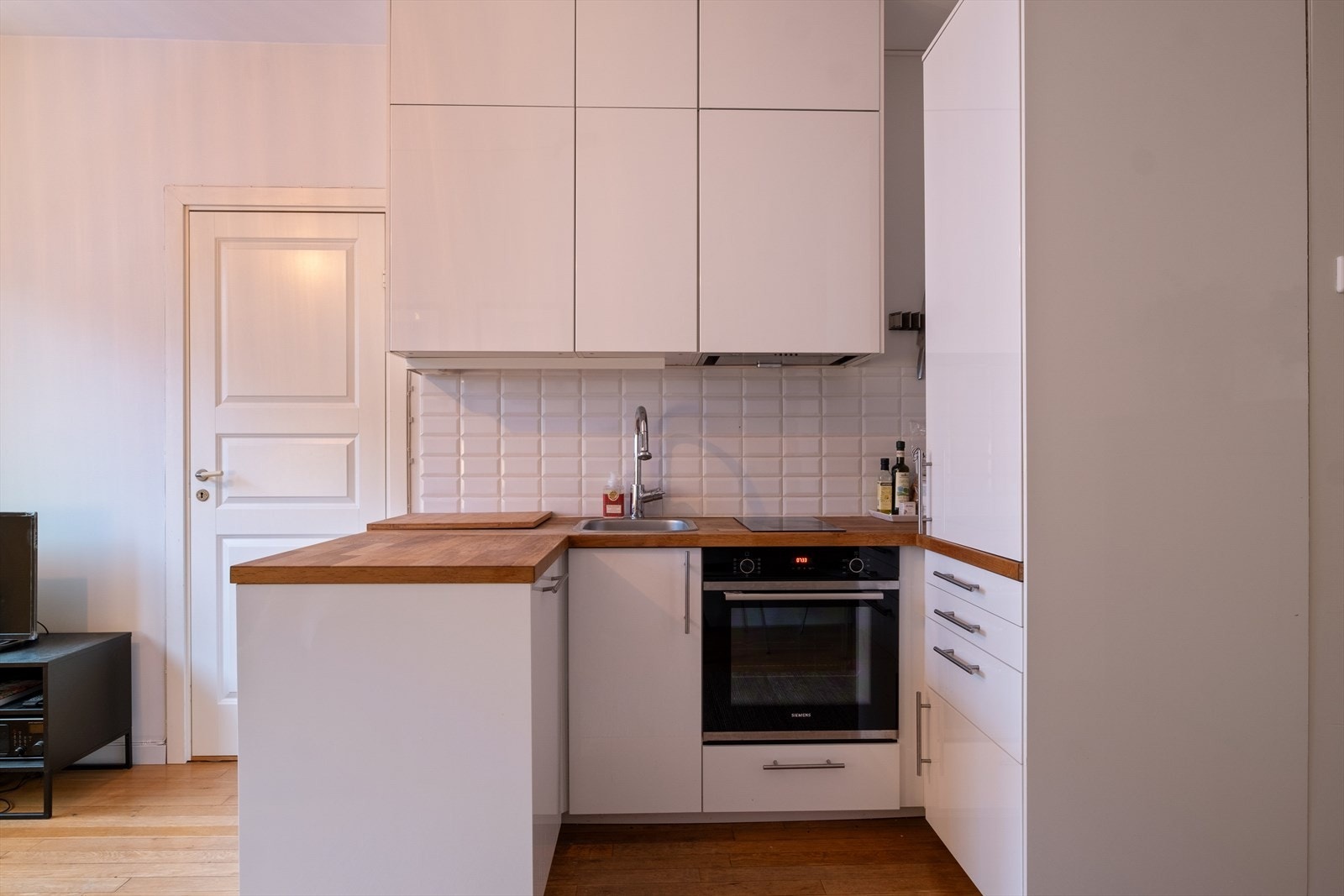 Vaskemaskinen er integrert i L formen til kjøkkenet Galleribilde