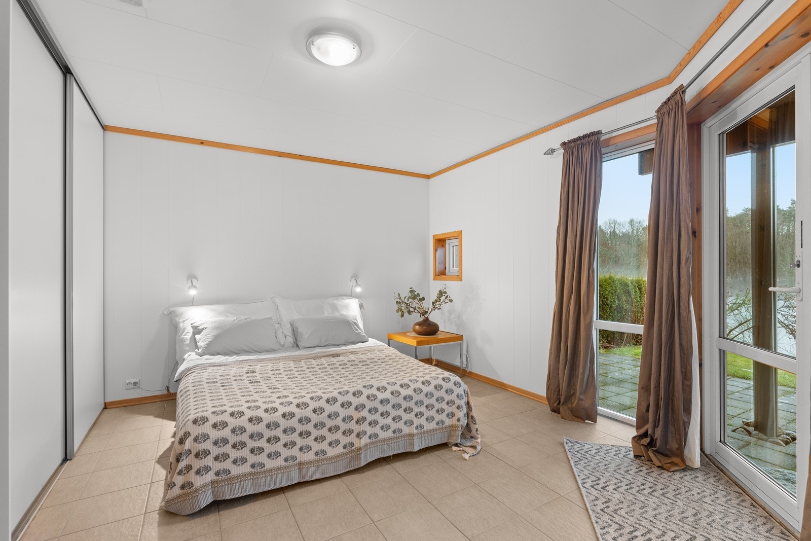 Romslig hovedsoverom med utgang til uteplass. Galleribilde