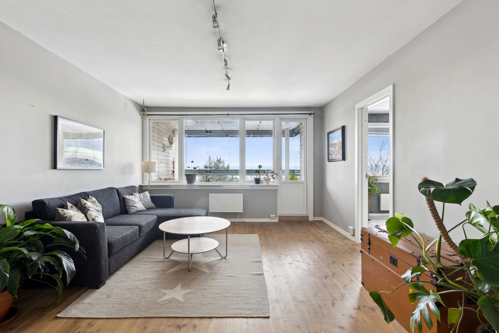 Lys og pen stue med utgang til vestvendt innglasset balkong Galleribilde