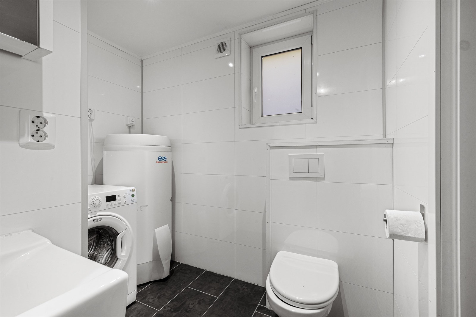 Lyst og innbydende bad med våtromsplater på vegg og flis på gulv Galleribilde