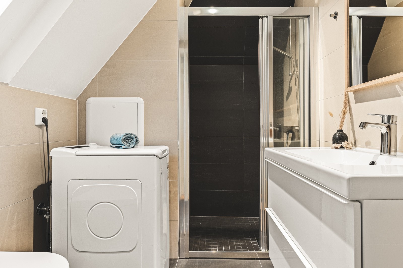 Badet er innredet med baderomsinnredning, dusj m/skyvedør, vegghengt toalett og opplegg for vaskemaskin. Galleribilde
