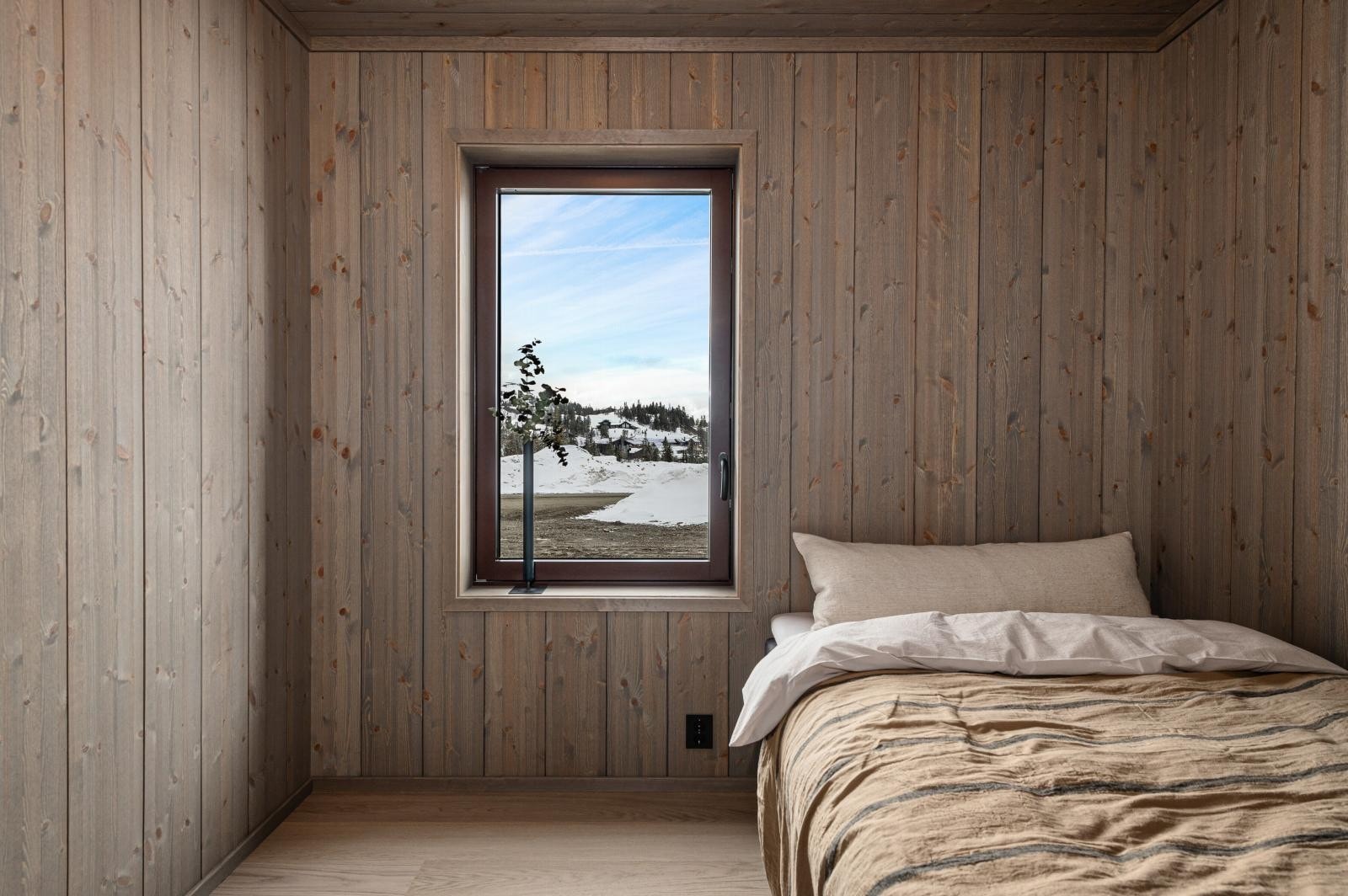 Med limtrepanel i fargen Dobbel Drivved på vegg og i himling, som er en klassisk og varig paneltype, får også soverommene et eksklusivt preg. Galleribilde