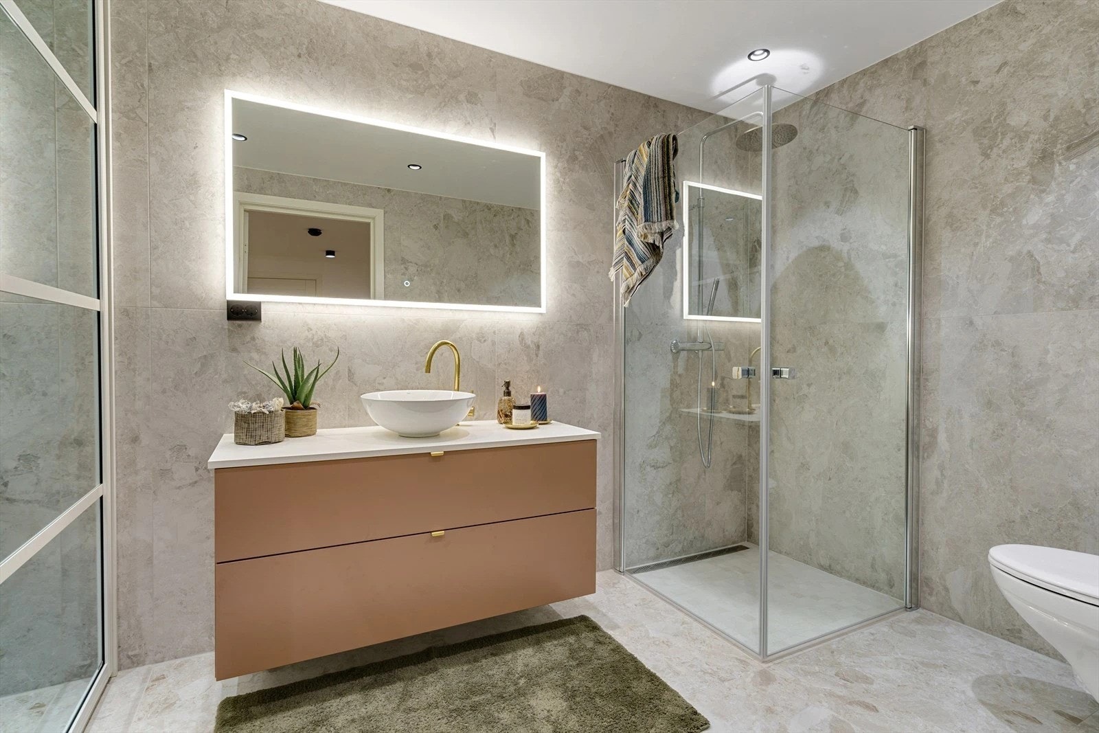 Rommet er utstyrt med dusjhjørne m/glassvegger, vegghengt toalett og en pen baderomsinnredning Galleribilde