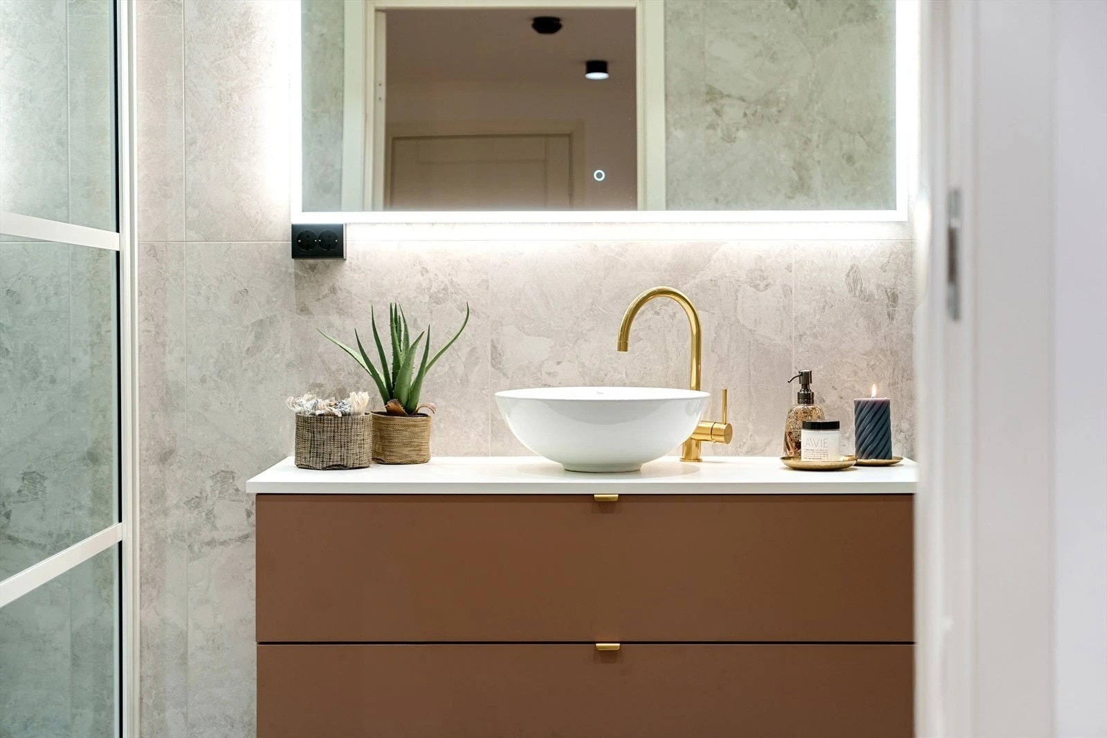 Innredningen har servant med to romslige skuffer under og stort vegghengt speil m/lys Galleribilde