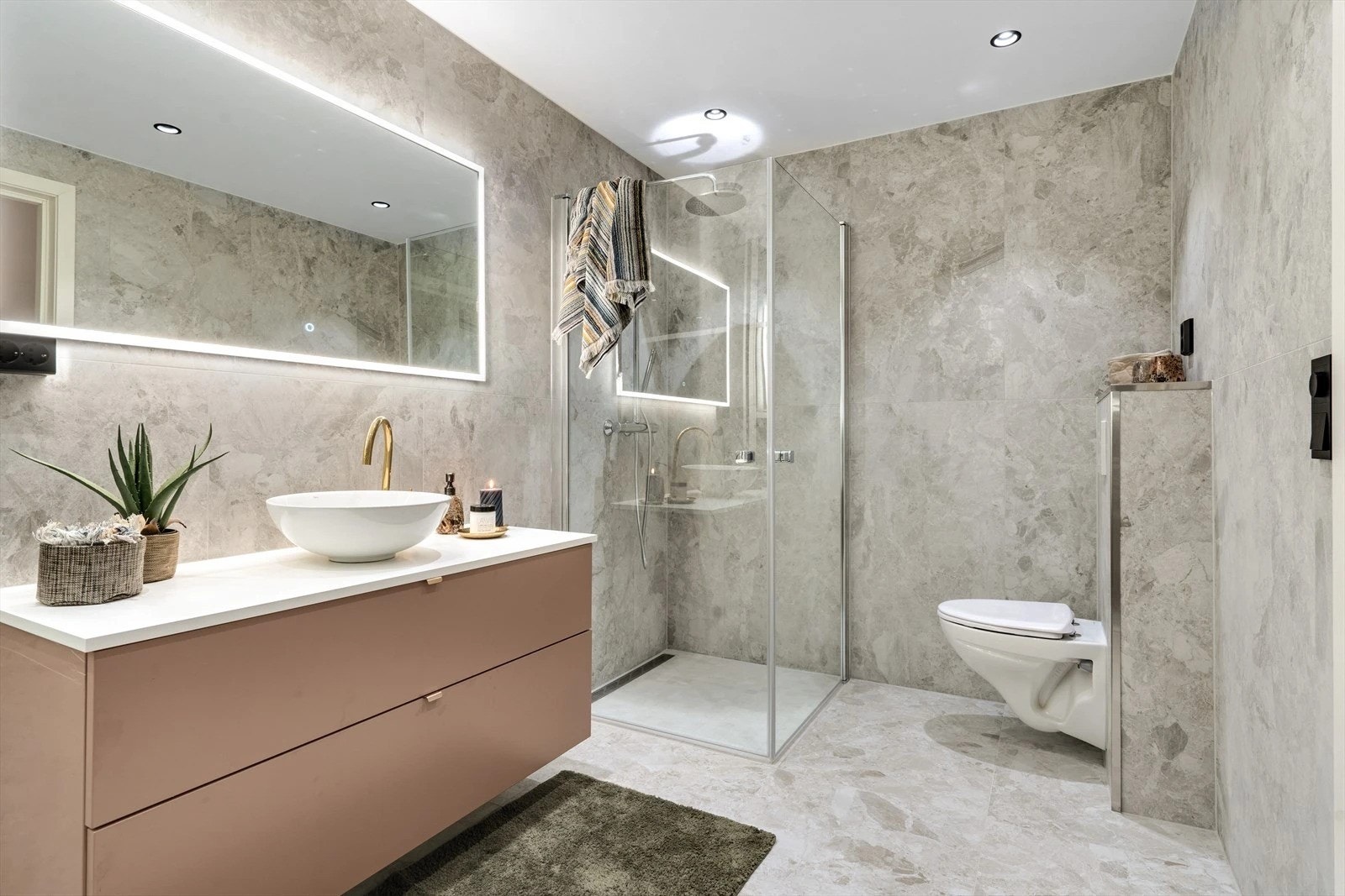 Det største badet er utført i samme stil med store fliser på både gulv og vegger Galleribilde