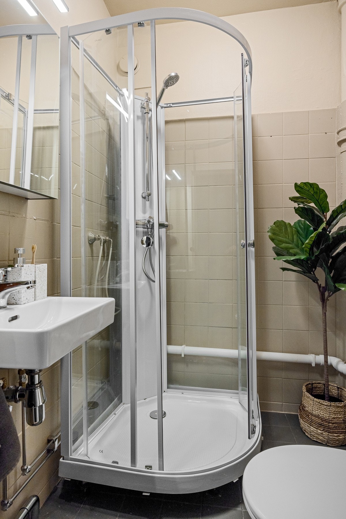 Bad med toalett og dusjkabinett i herdet glass. Galleribilde