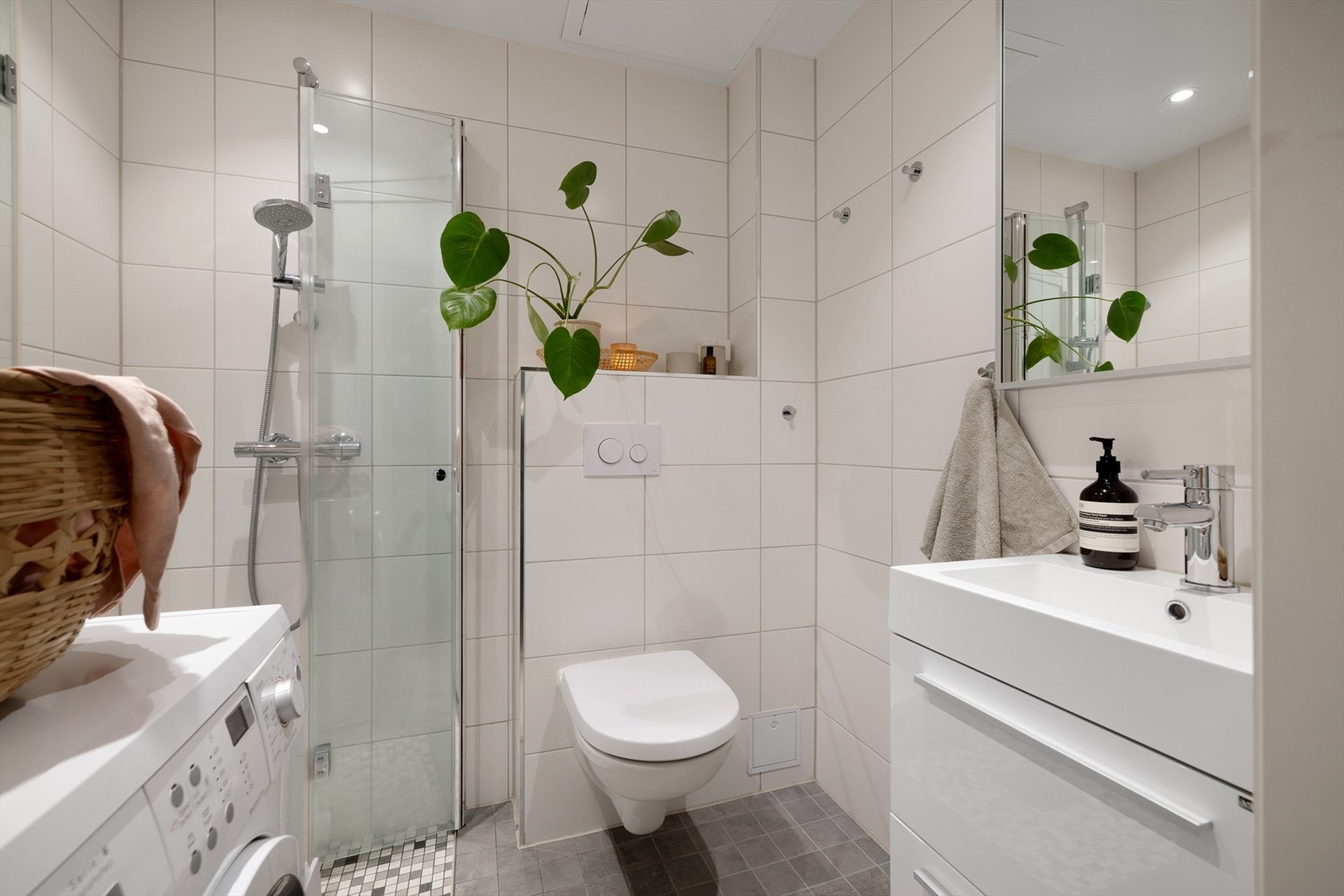 Lyst flislagt bad med varme i gulv og opplegg for vaskemaskin Galleribilde