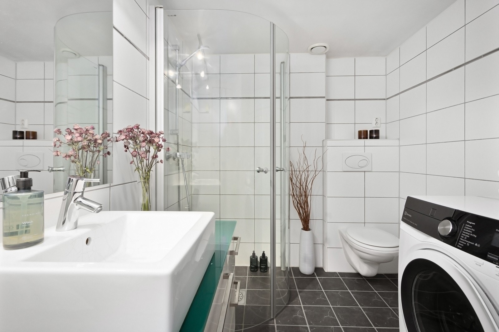 Romslig bad med flislagte overflater, vannbåren varme og opplegg for vaskemaskin. Galleribilde