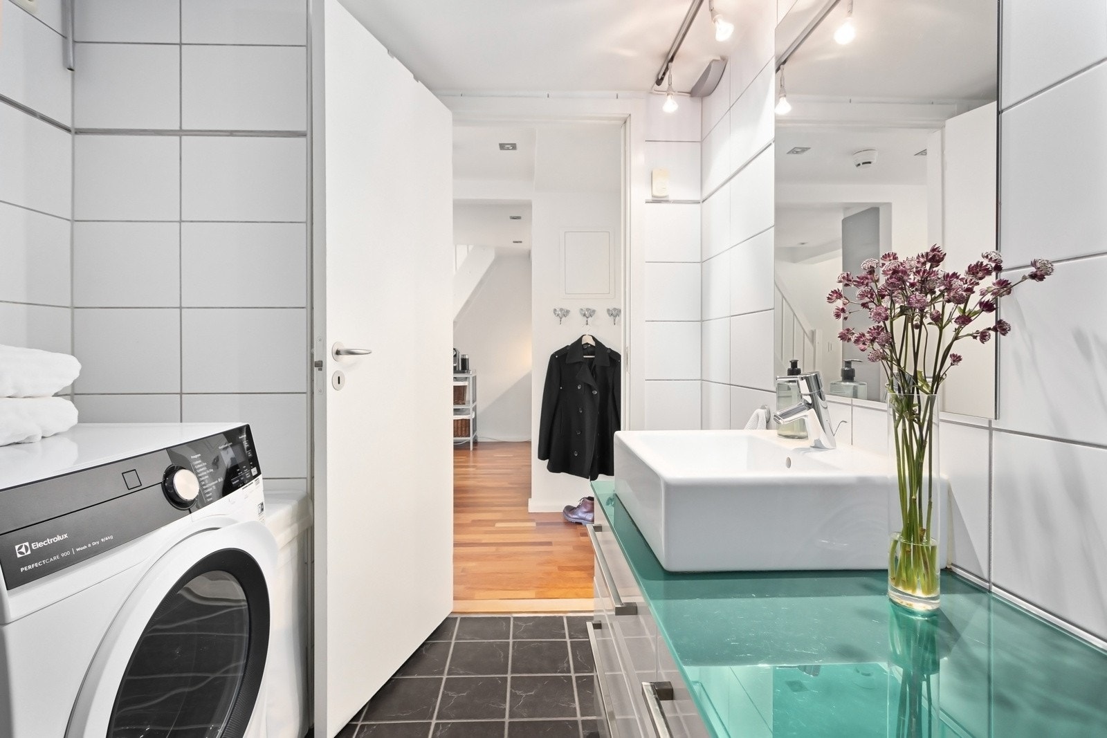 Innredning består av servant, vegghengt toalett, dusjhjørne med innfellbare buede glassdører. Galleribilde