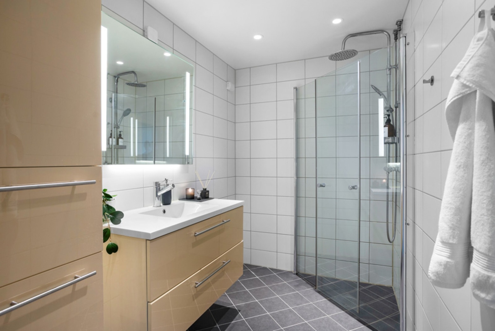 Lyst, flislagt baderom med gulvvarme og downlightsbelysning i taket - Badet ble pusset opp i regi av borettslaget i 2019 og fremstår moderne Galleribilde