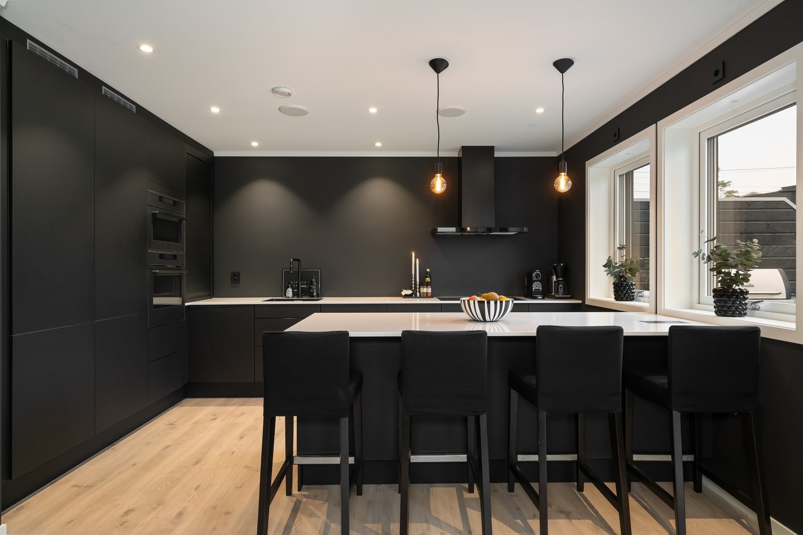 Sort kjøkken med høyskap og slette fronter. Galleribilde