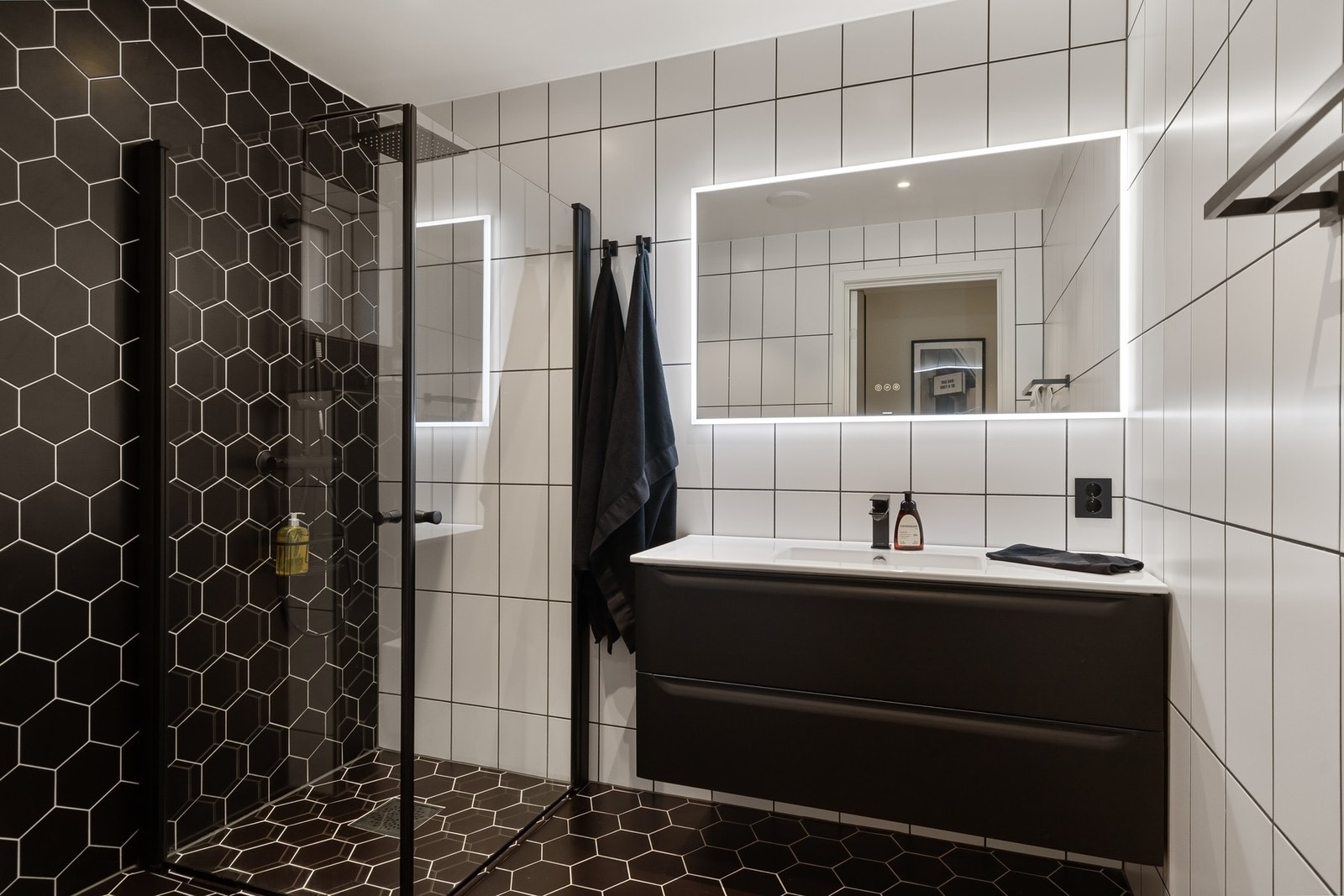 Lekkert bad i 1. etg. med vegghengt toalett, dusjhjørne, servantskap og speil med lys. Galleribilde