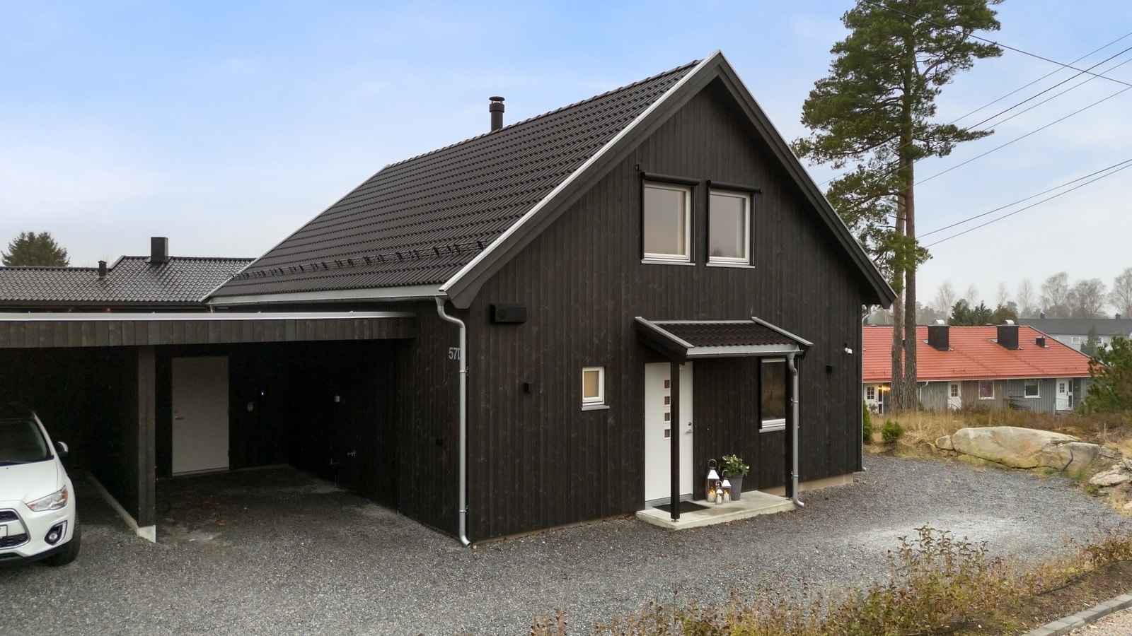 Parkering i carport med isolert sportsbod med frostsikringsovn og elbillader. Galleribilde