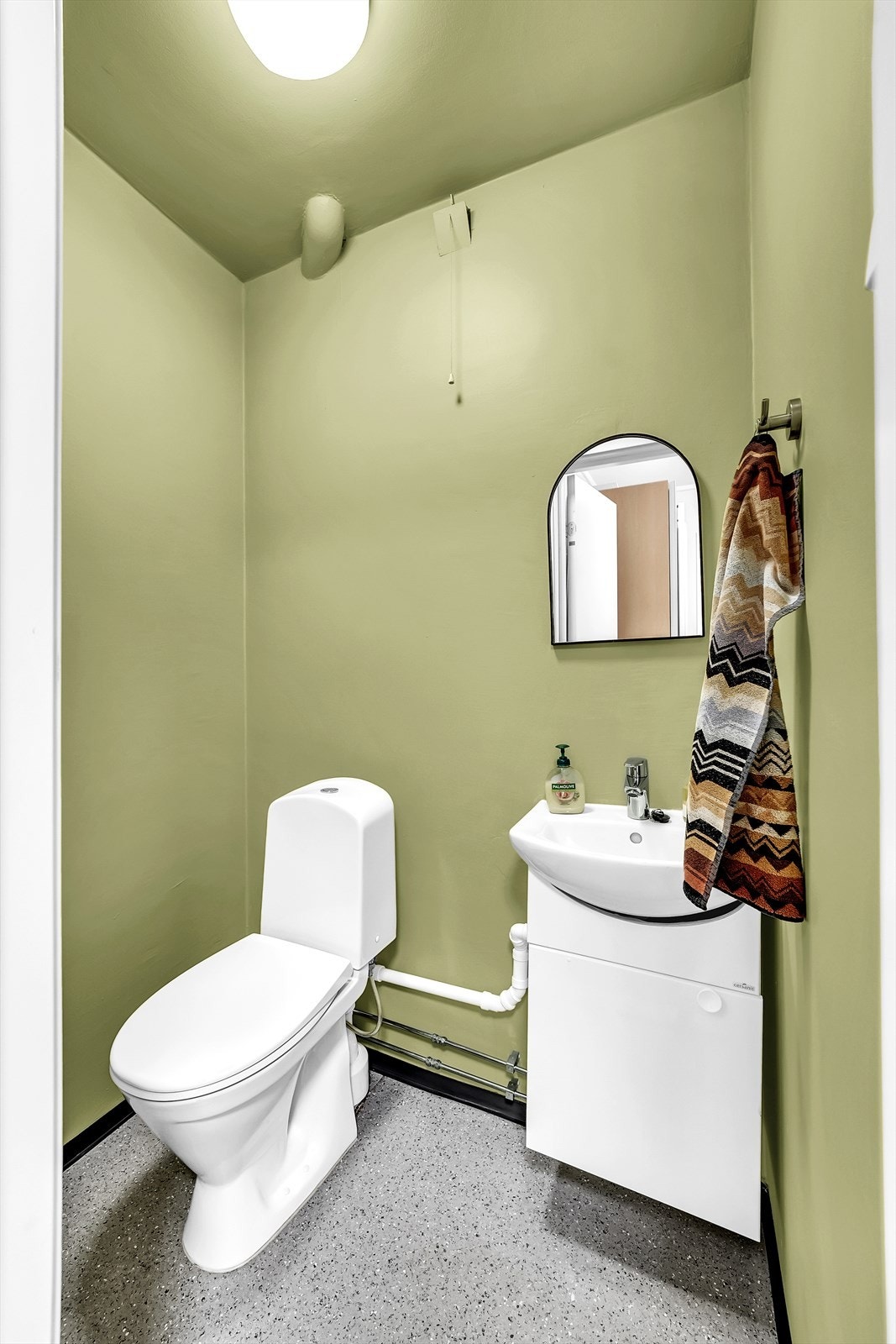 Praktisk toalettrom med servantinnredning og gulvstående toalett. Galleribilde