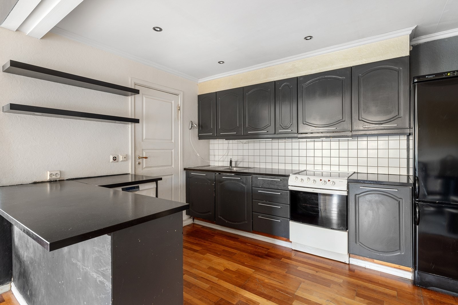 Kjøkkeninnredningen har profilerte fronter, benkeplate i laminat, nedfelt kum i rustfritt stål, belysning under overskap og fliser på vegg Galleribilde