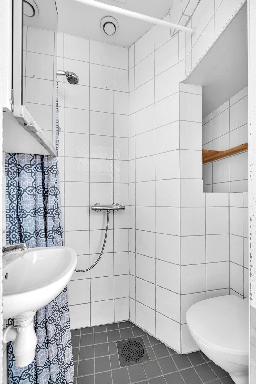 Flislagt bad med varmekabler, vegghengt toalett og servant Galleribilde