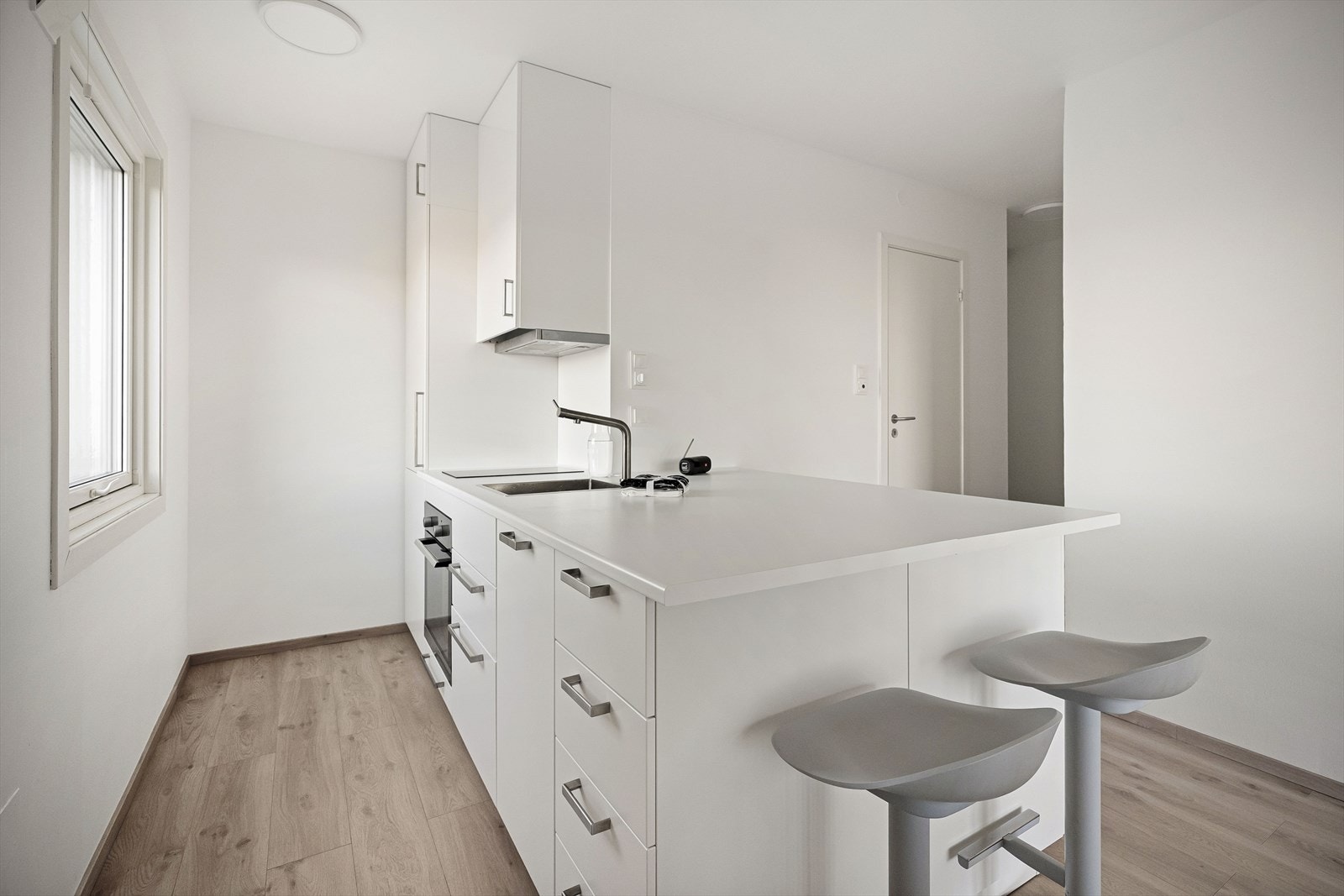 Et romslig og moderne kjøkken som innbyr til sosial matlaging Galleribilde