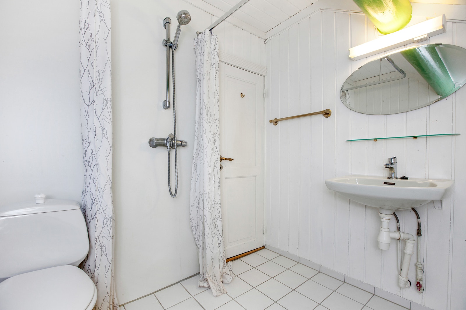 Flislagt bad med toaslett, servant og dusj. Galleribilde