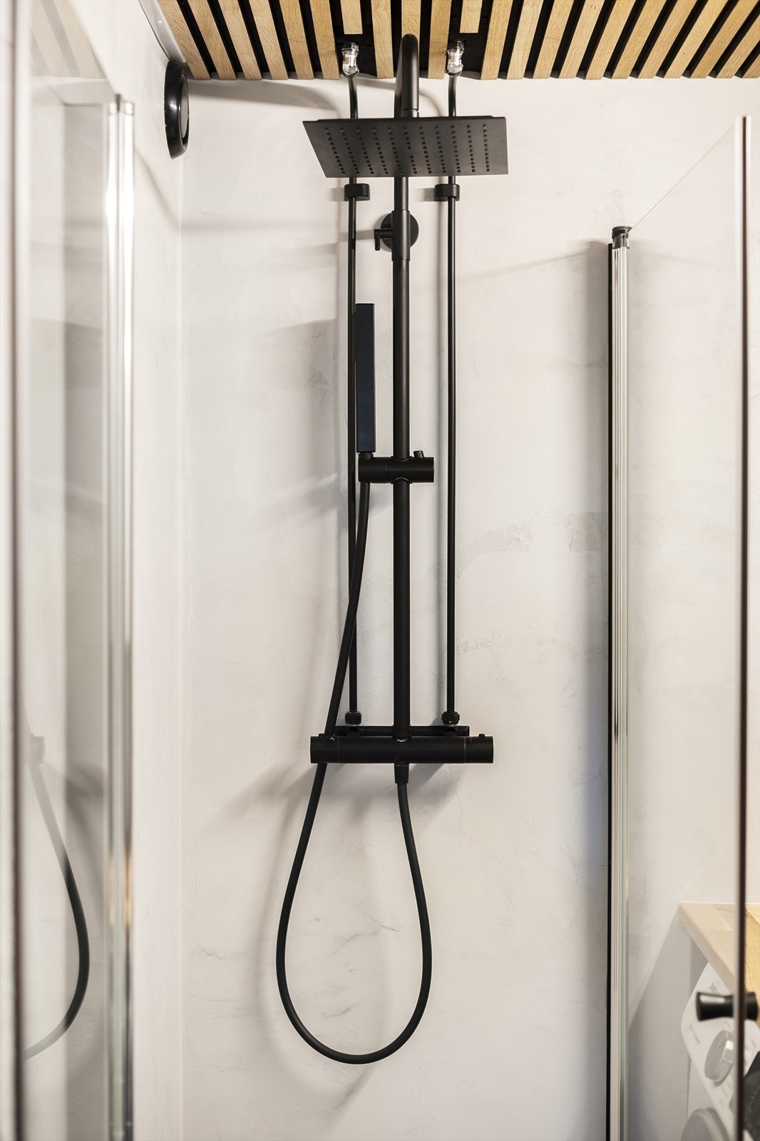 Rommet er innredet med vegghengt klosett, dusjhjørne med svingbare glassdører og baderomsinnredning med skap, nedfelt servant og speilskap. Galleribilde