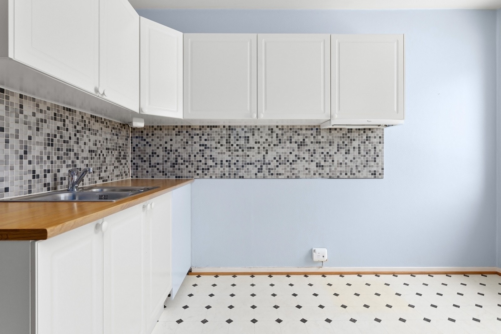 Kjøkkeninnredning med hvite profilerte fronter og laminert benkeplate Galleribilde