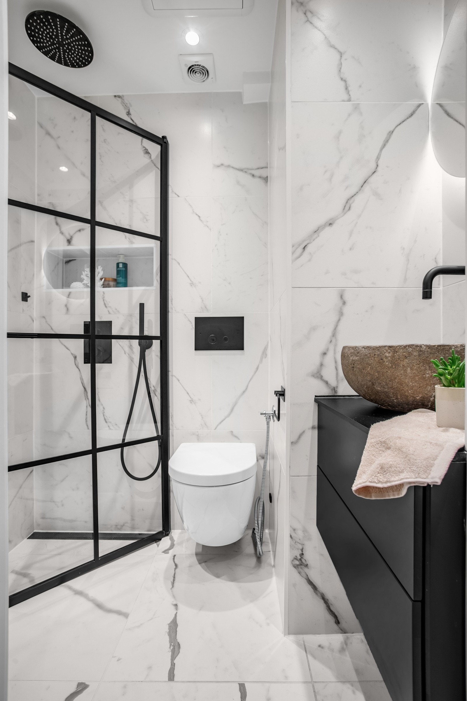 Svært delikat bad med integrert dusjarmatur og takhengt regnfallsdusj. Nisje for dusjartikler i dusjsonen. Galleribilde